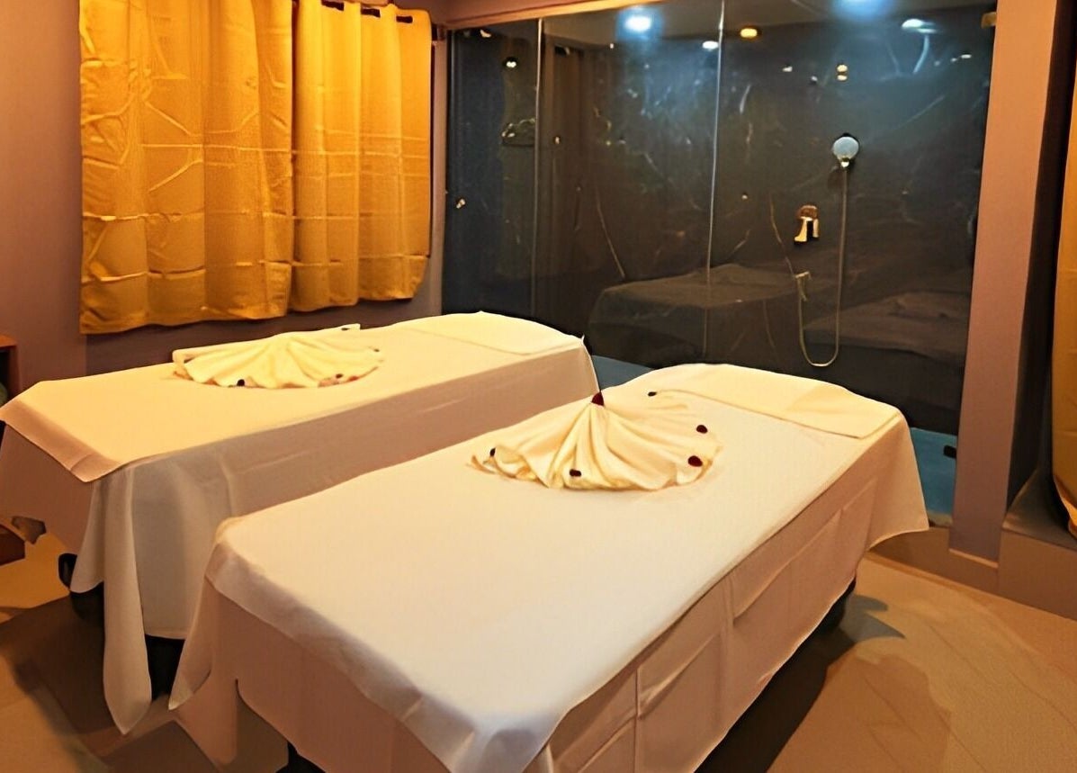 Relaxing treatment room at Ajna Spa, Bengaluru, Karnataka, IN, featuring two massage tables with elegant decor.