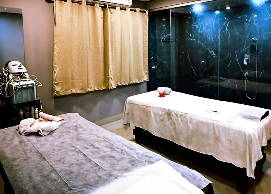 Ajna Spa massage room in Bengaluru, Karnataka, IN featuring two therapy beds and a serene ambiance.