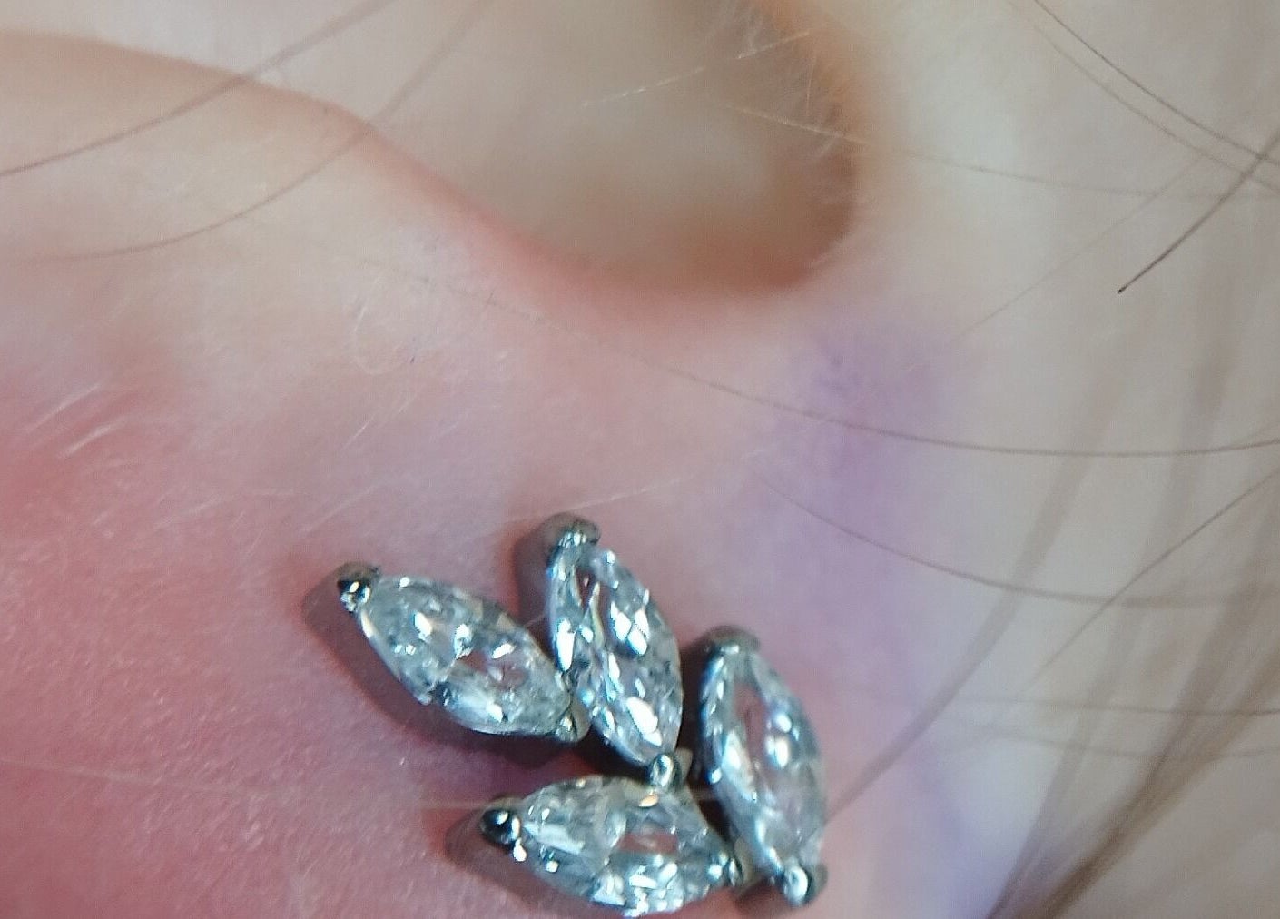 Piercing com pedras brilhantes na orelha em Ema Body Piercing, Vila Nova De Gaia, Porto, PT.