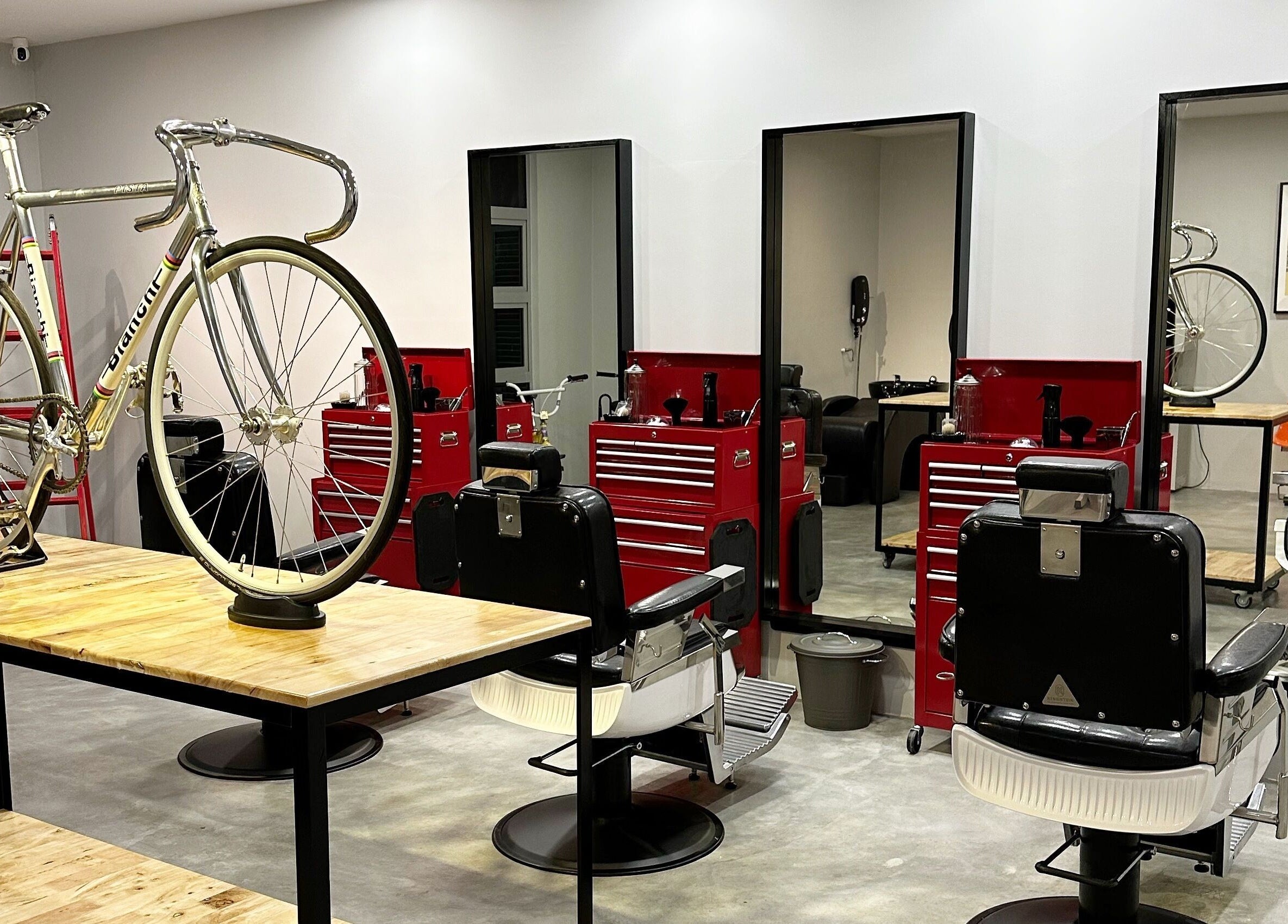 Interior of Pedal Barbers, Shah Alam, Selangor, MY featuring a vintage bicycle and stylish barber chairs.
