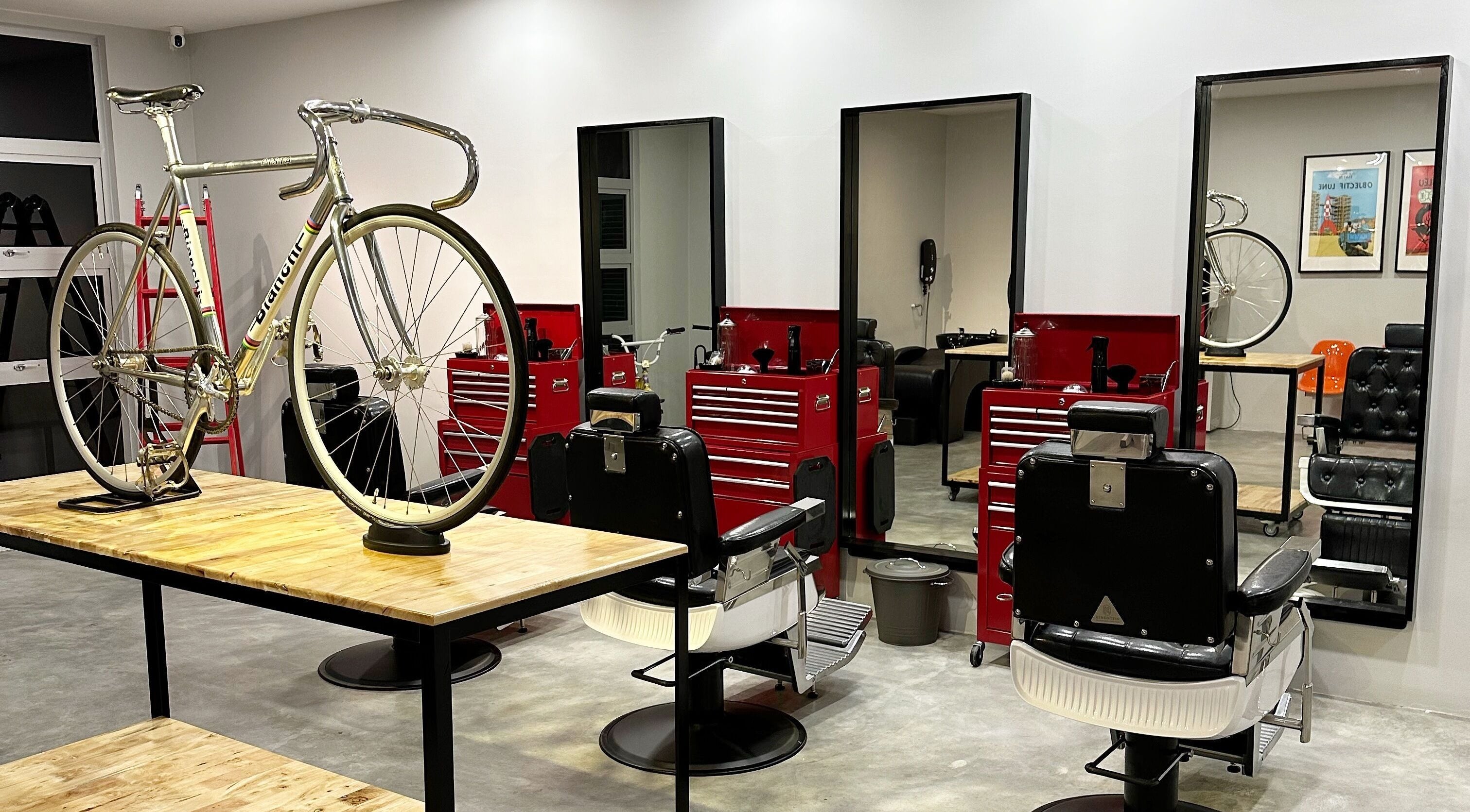 Interior of Pedal Barbers, Shah Alam, Selangor, MY featuring a vintage bicycle and stylish barber chairs.