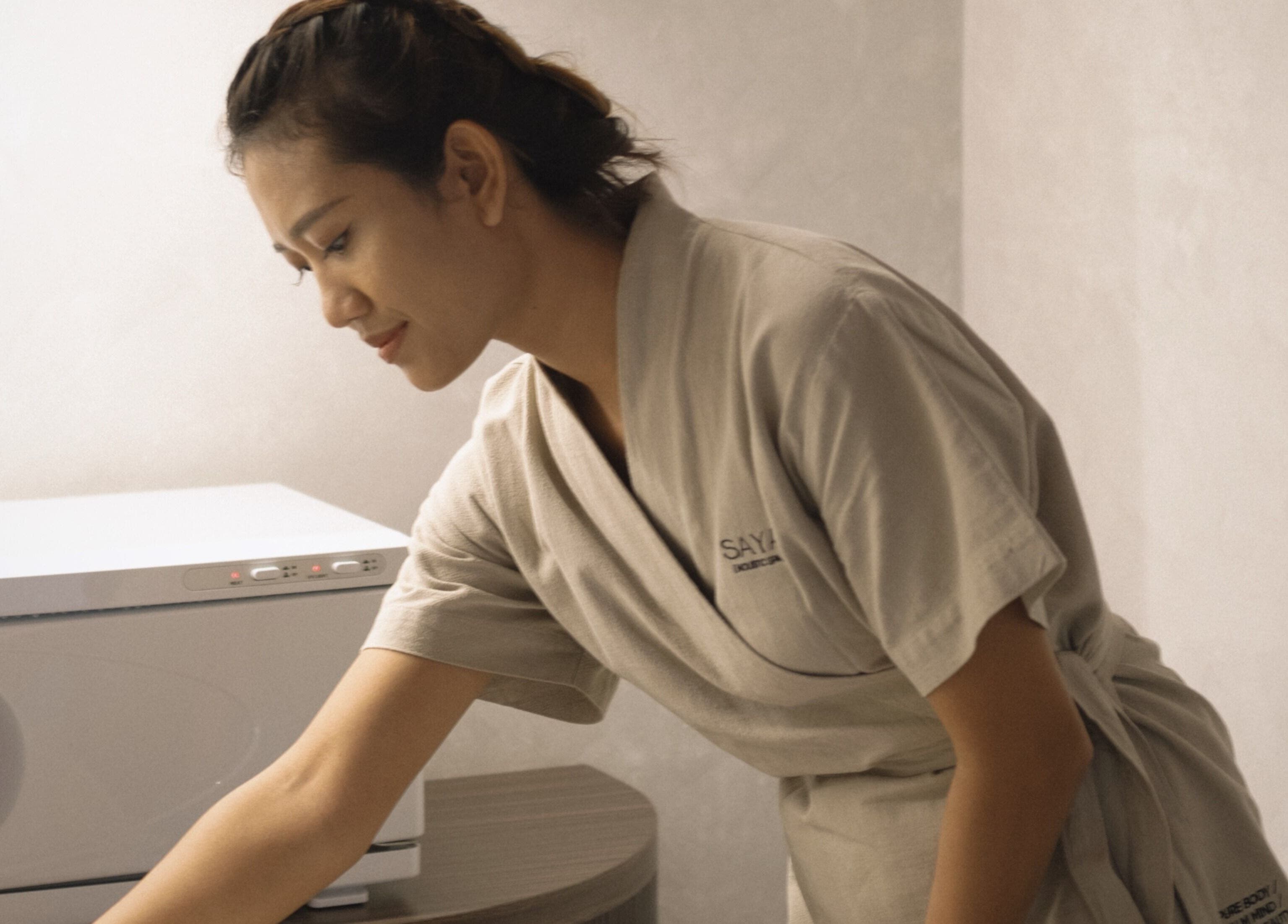 Therapist preparing a serene space at Saya Holistic Spa in Bali, Bali, ID for a rejuvenating experience.