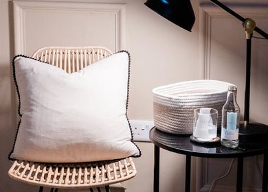 Elegant corner of The Skin Studio, London, England with a chair, soft pillow, and side table setup.
