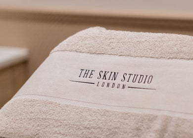 Soft towel with 'The Skin Studio' logo, London, England, GB highlighting luxury skincare.