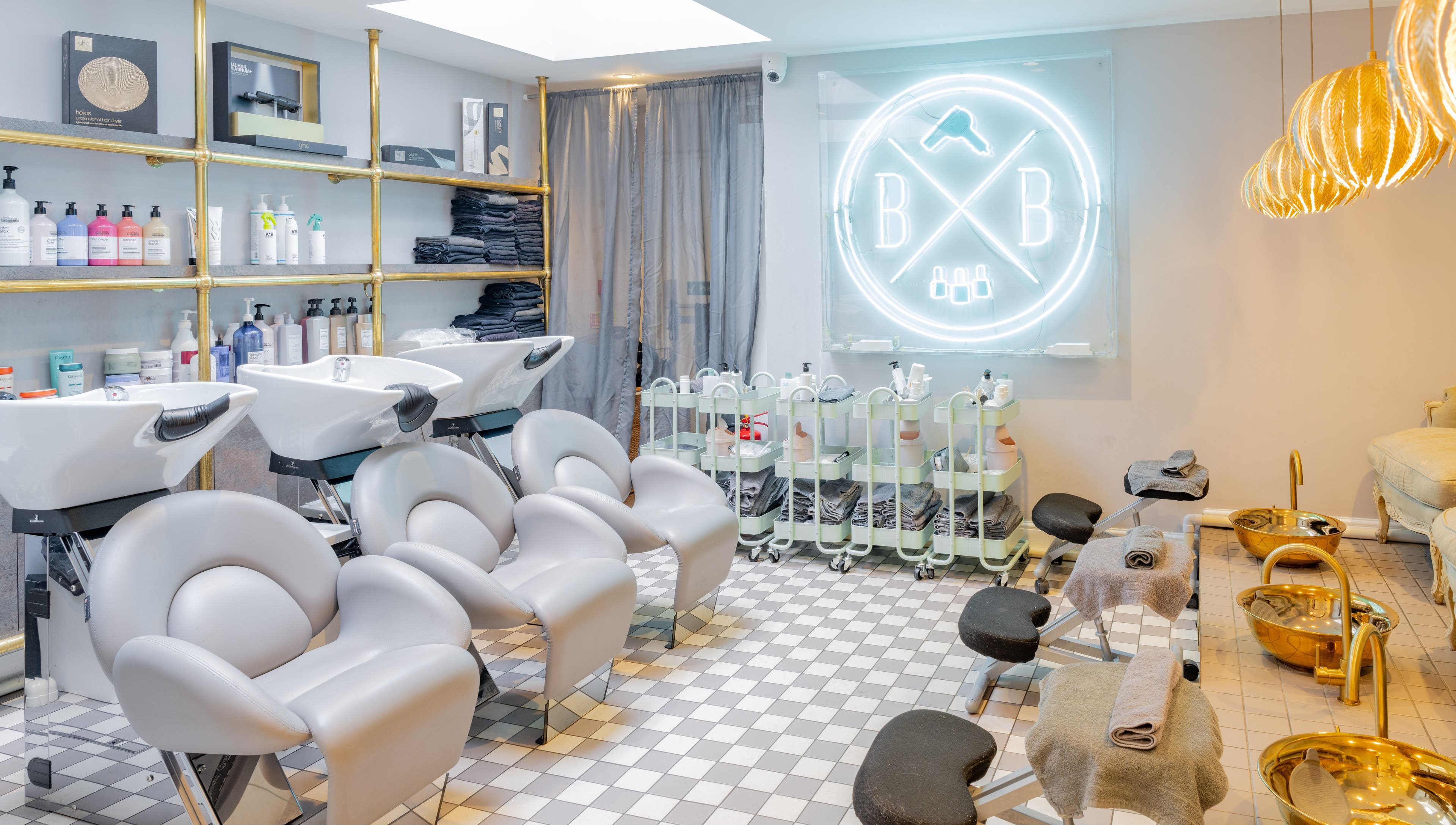 Blush + Blow London salon's elegant interior in London, England, GB, featuring modern styling stations and chic decor.
