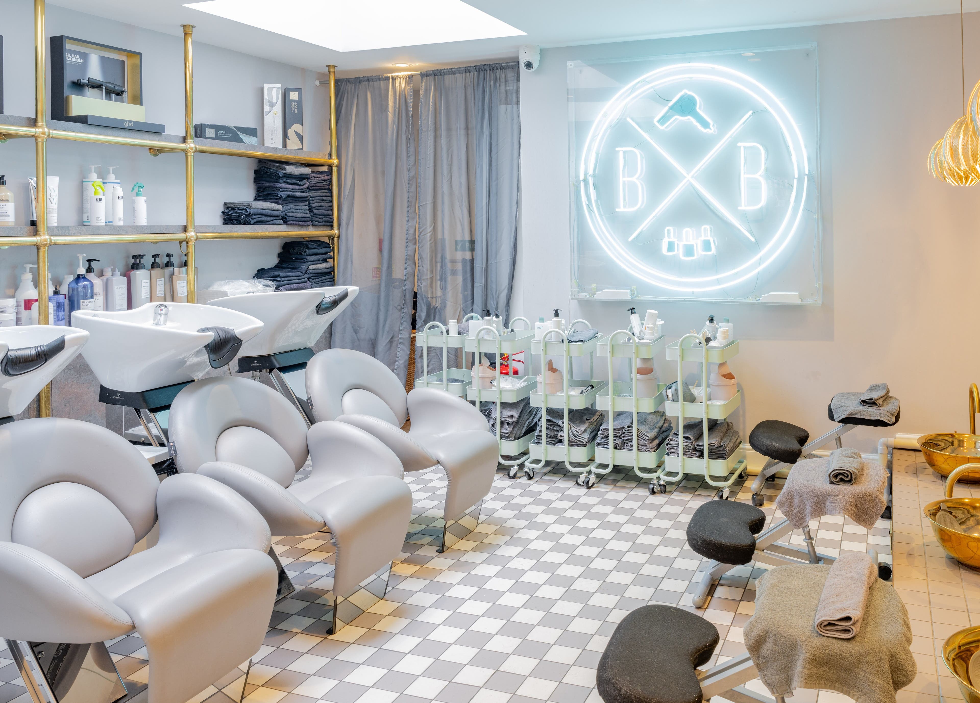 Blush + Blow London salon's elegant interior in London, England, GB, featuring modern styling stations and chic decor.