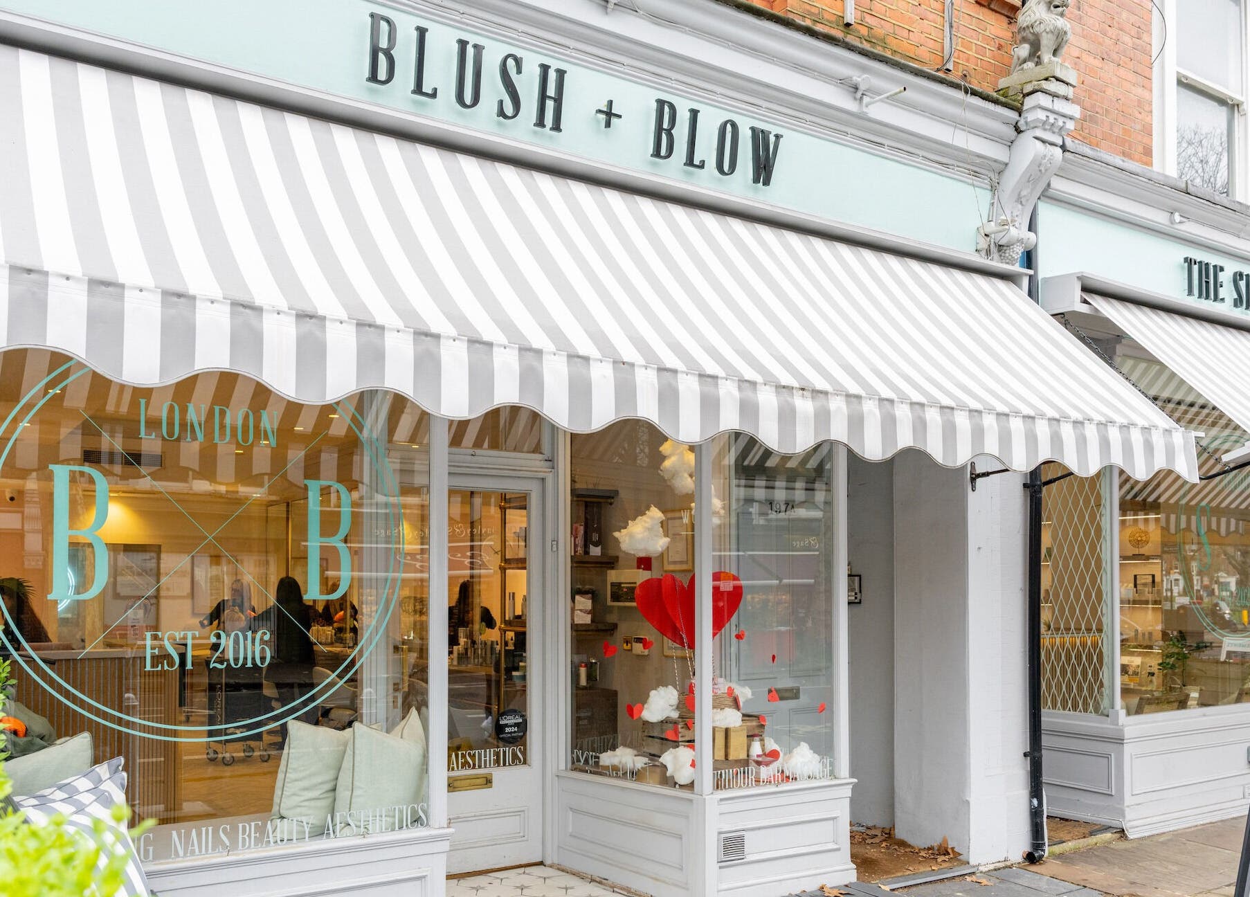 Exterior of Blush + Blow London with striped awning in London, England, GB.