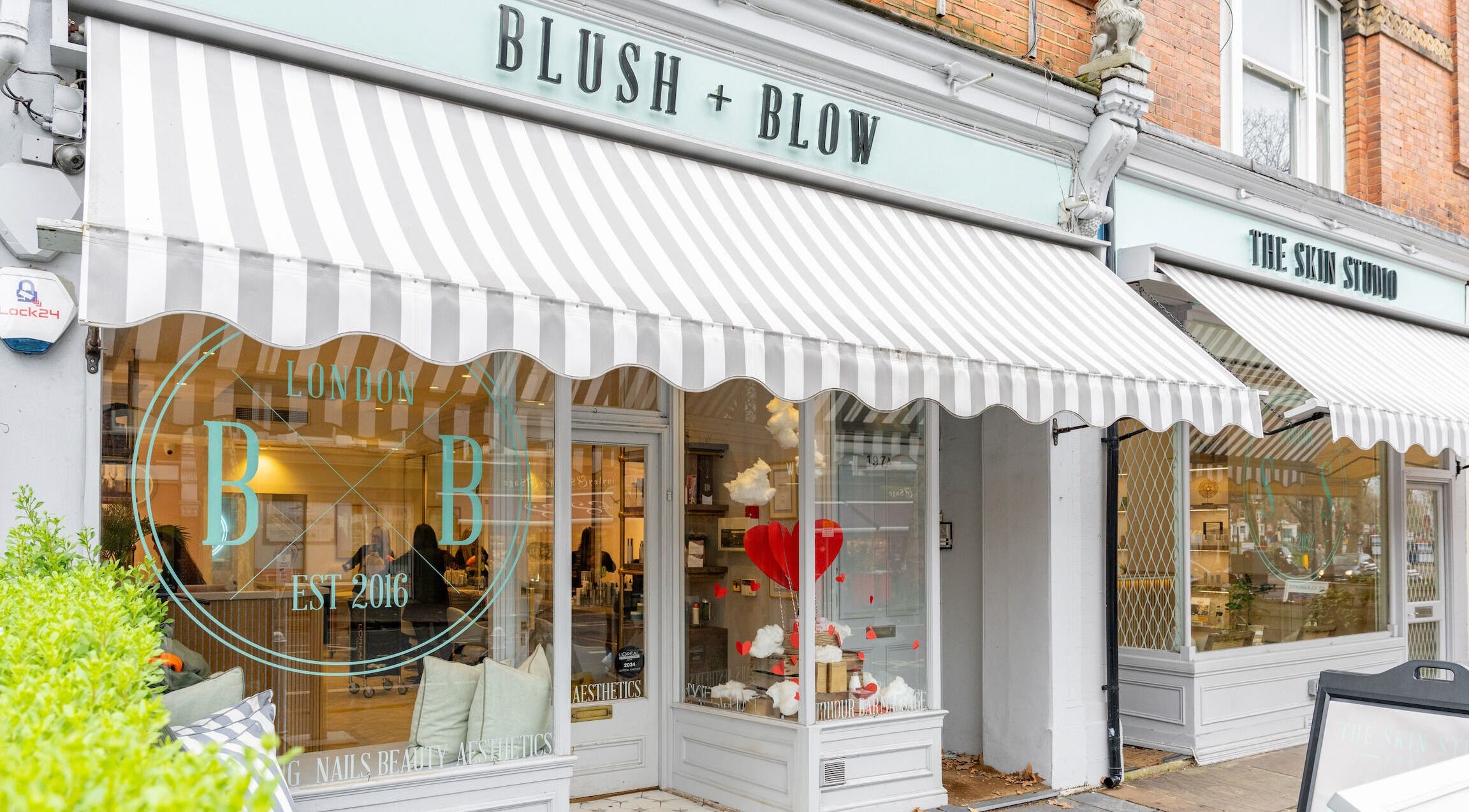 Exterior of Blush + Blow London with striped awning in London, England, GB.