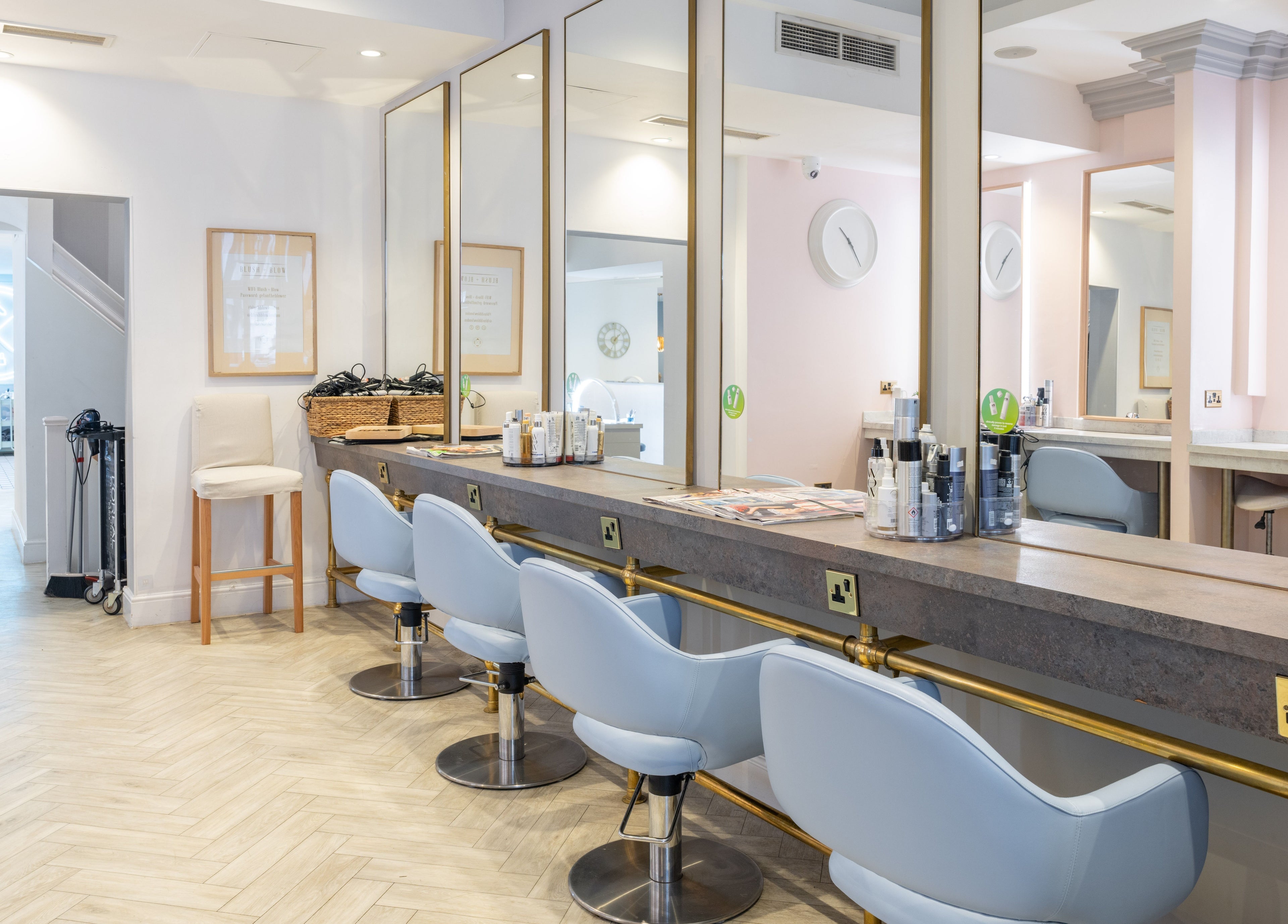 Elegant salon interior with styling stations at Blush + Blow London, London, England, GB.