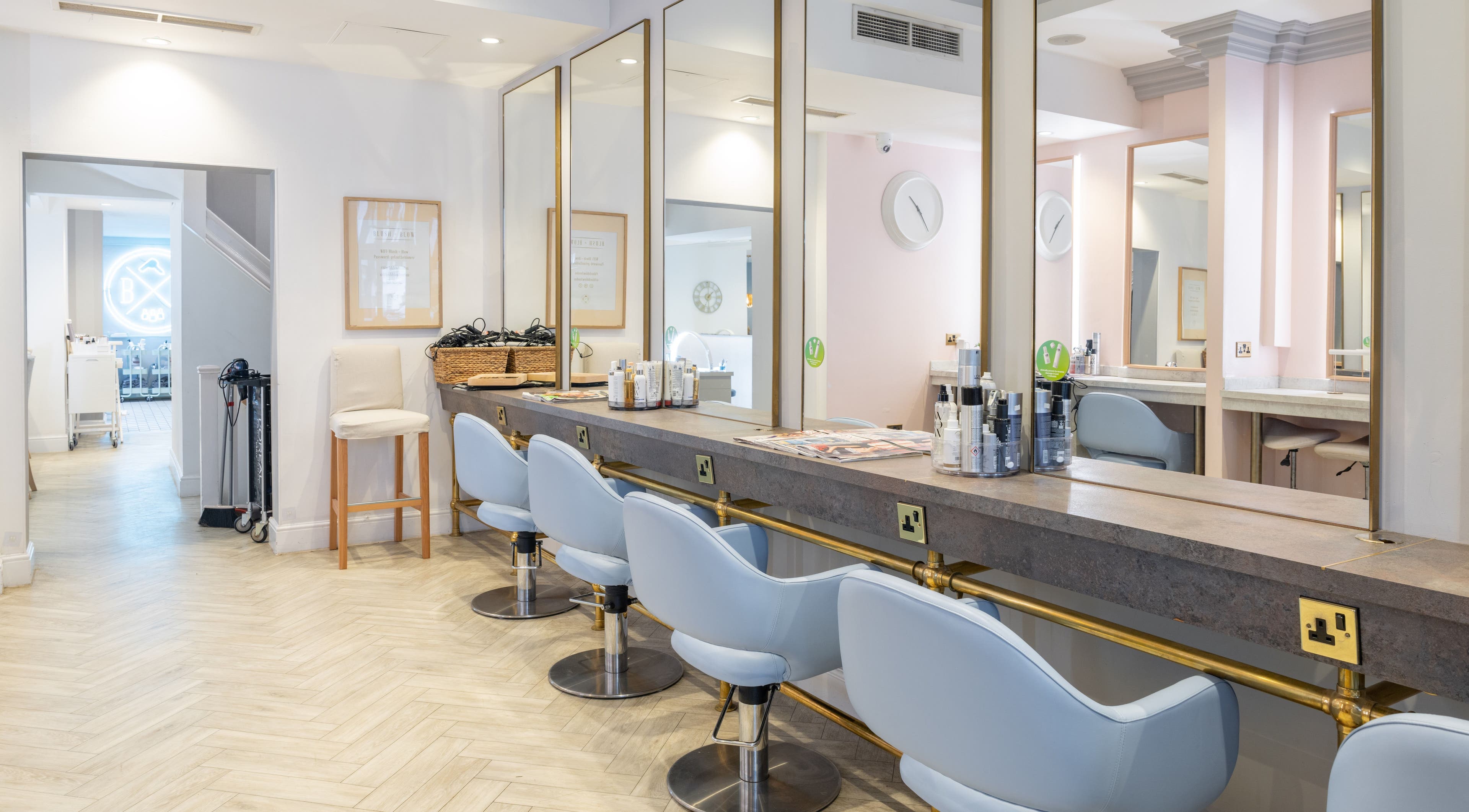 Elegant salon interior with styling stations at Blush + Blow London, London, England, GB.