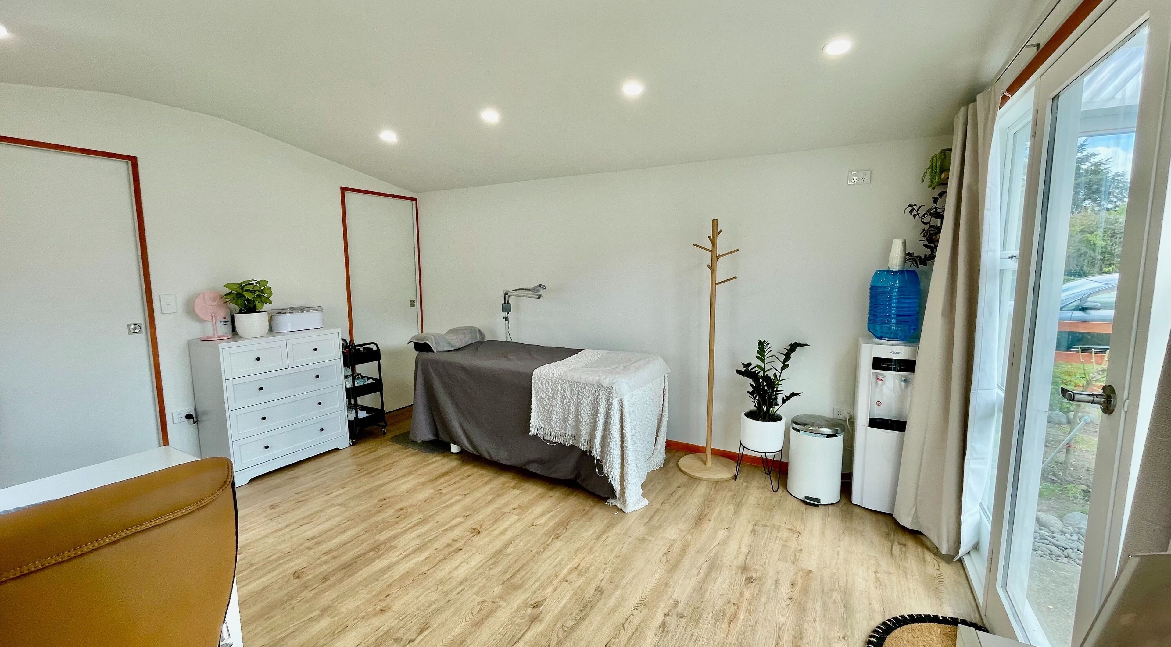 Relaxing treatment room at Mercury Beauty Studio, Christchurch, Canterbury, NZ with massage table.