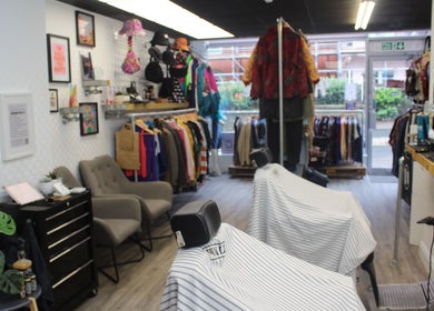 Interior of Renegade: Cuts and Clobber, Douglas, showcasing stylish decor and vintage garments.