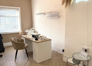 Elegant treatment room at Belleamie Beauty, Newport, Wales, GB with cozy decor and nail polish displays.