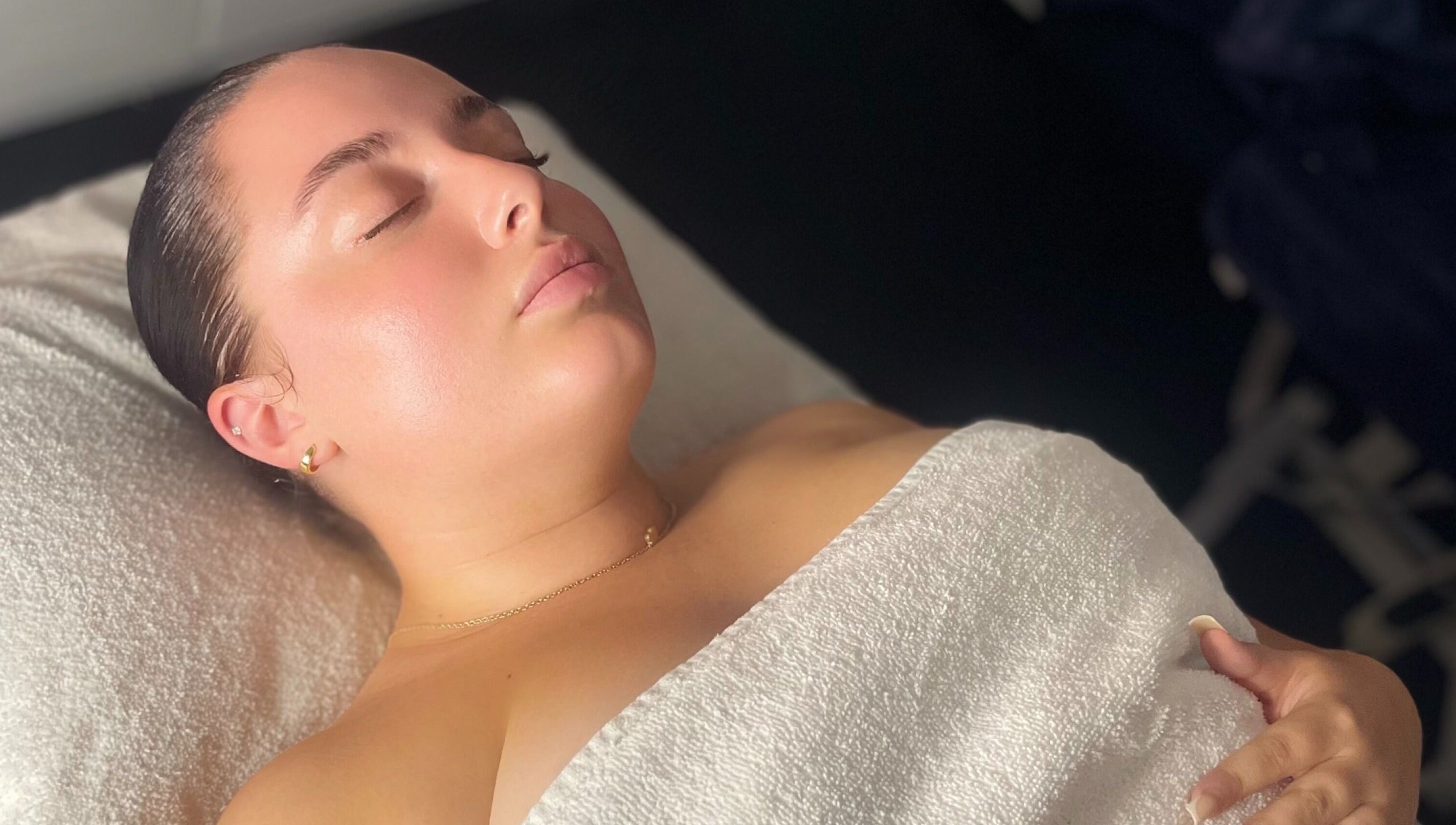 Relaxing spa treatment at The Secret Garden Spa, Weymouth, England, GB. Woman wrapped in a towel, eyes closed.