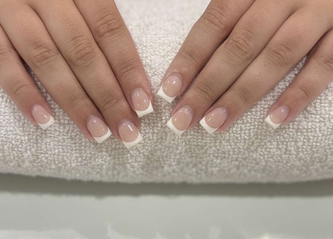 French manicure at The Secret Garden Spa, Weymouth, England, GB. Perfectly polished nails on a soft towel.