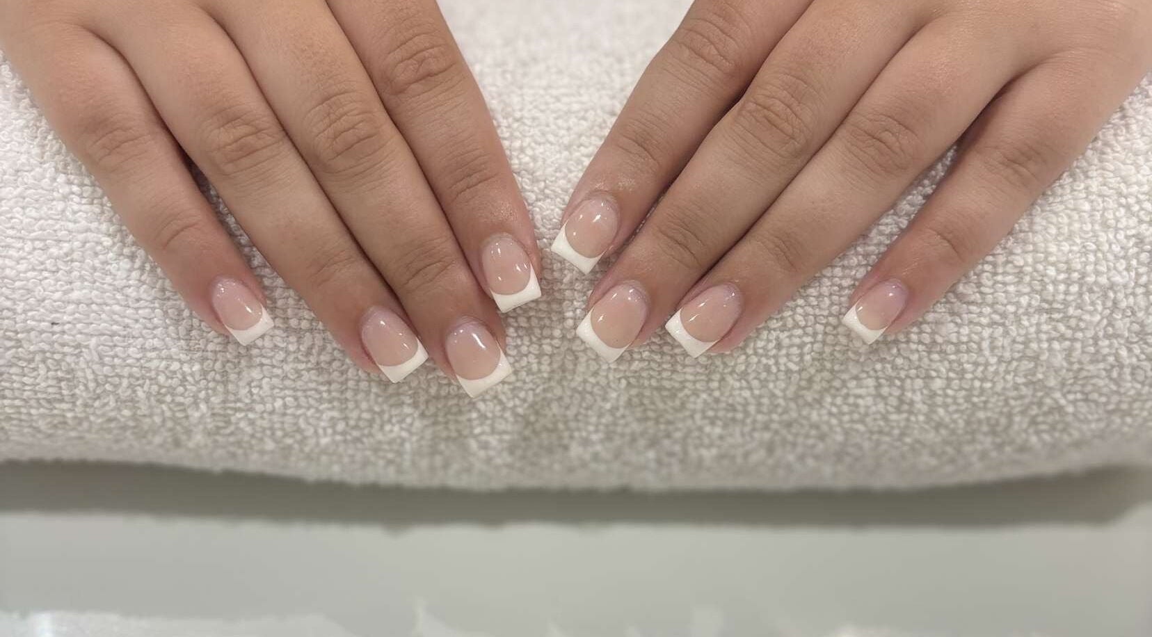French manicure at The Secret Garden Spa, Weymouth, England, GB. Perfectly polished nails on a soft towel.