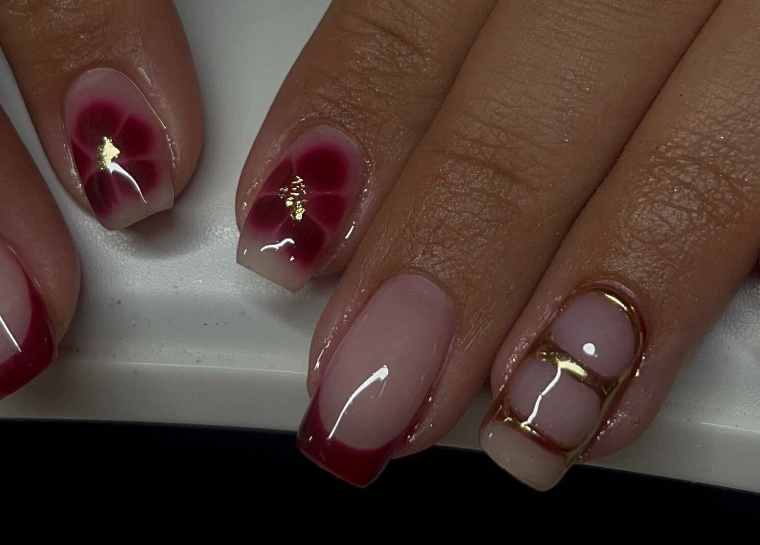 Stylish red and gold nail art at Josie Leah’s Beauty in Montriond, Auvergne-rhône-alpes, FR.