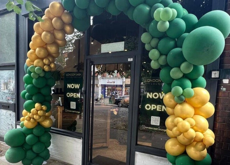 Entrance of London Lash Lounge Ealing, London, England, GB, adorned with green and gold balloons, now open.