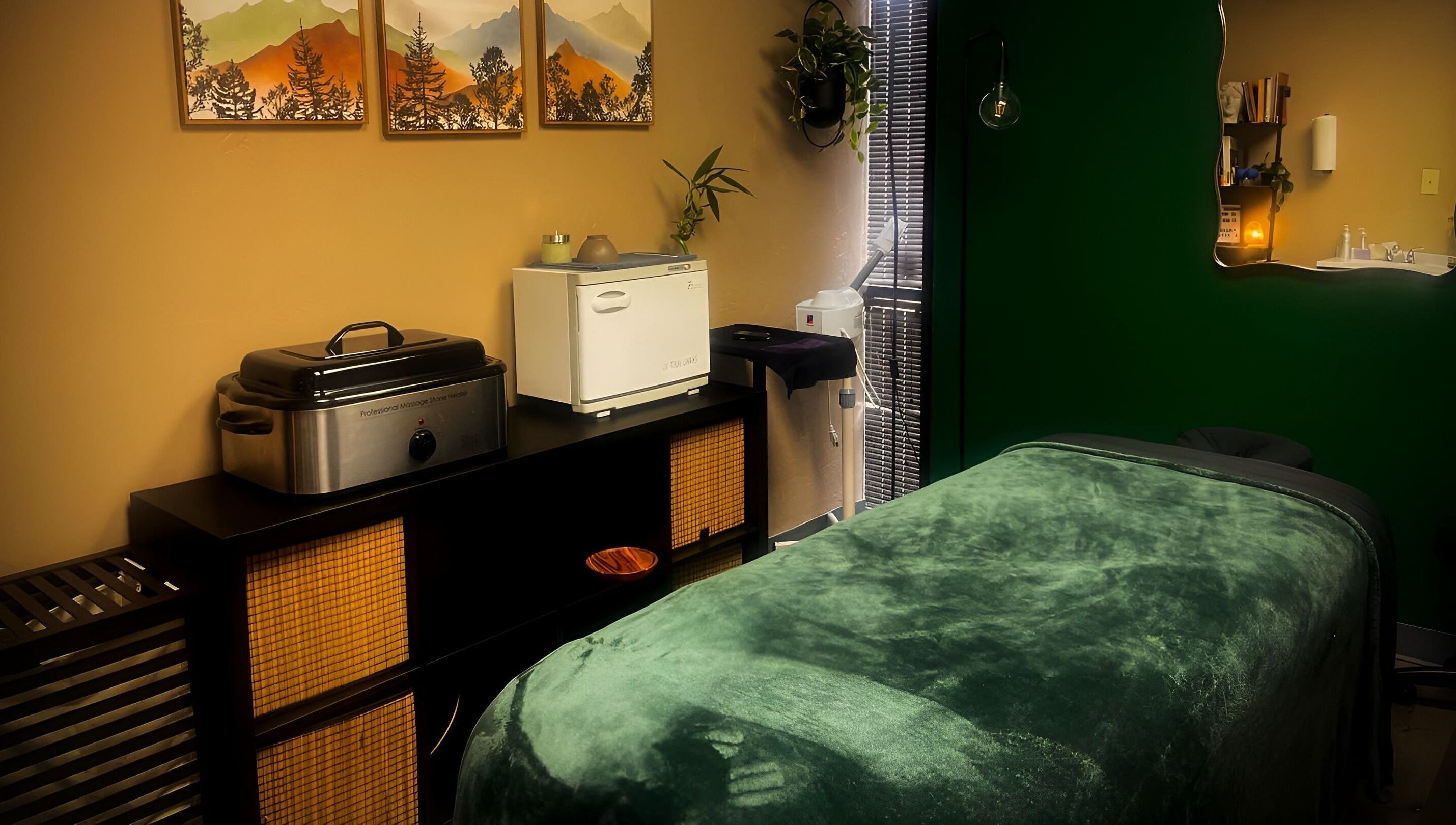 Tranquil massage room at Body By Raquel in Tempe, Arizona, US with green decor and calming atmosphere.