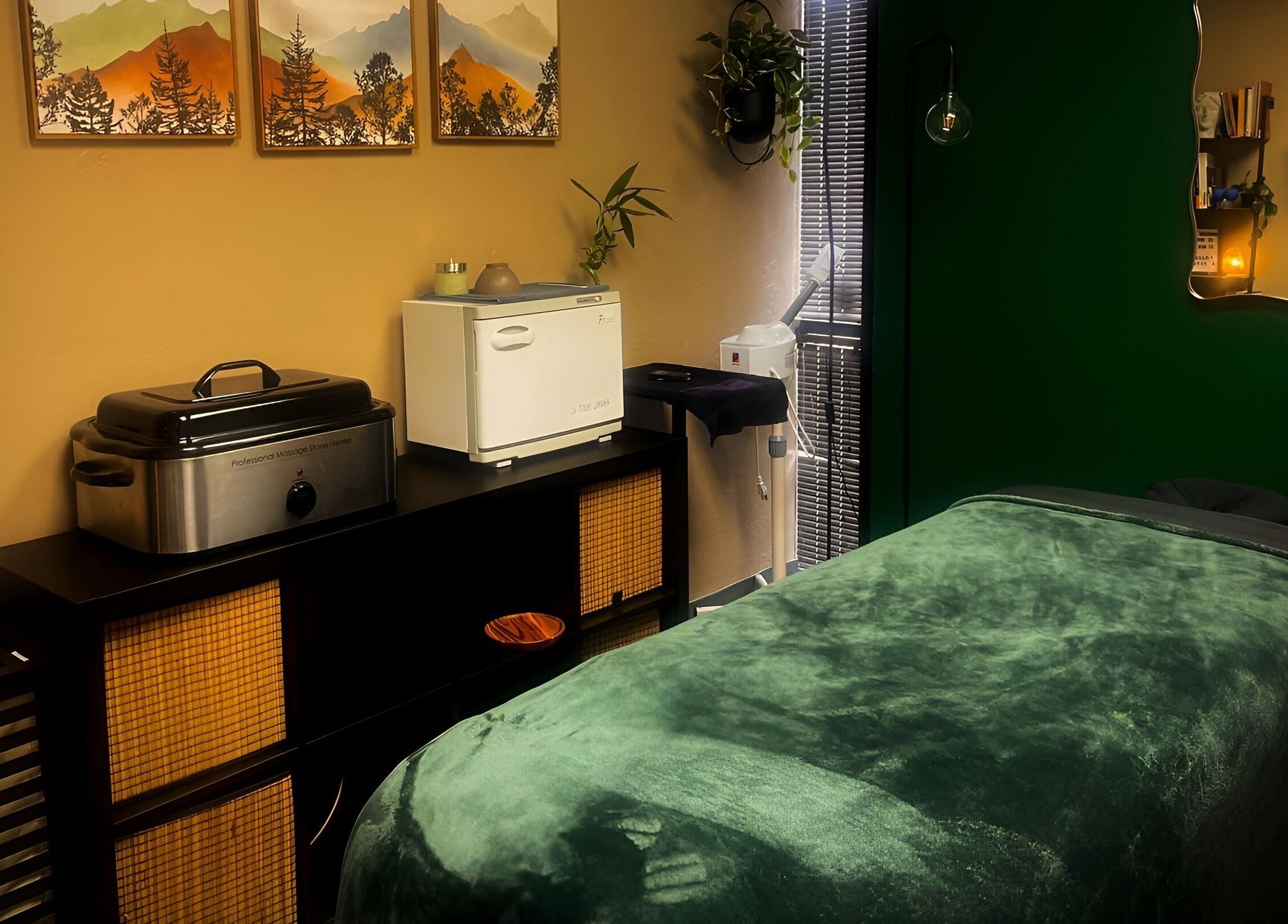 Tranquil massage room at Body By Raquel in Tempe, Arizona, US with green decor and calming atmosphere.