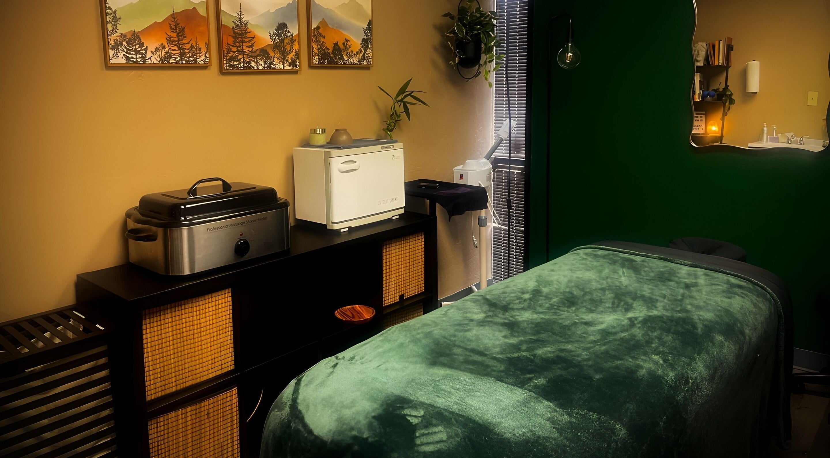 Tranquil massage room at Body By Raquel in Tempe, Arizona, US with green decor and calming atmosphere.