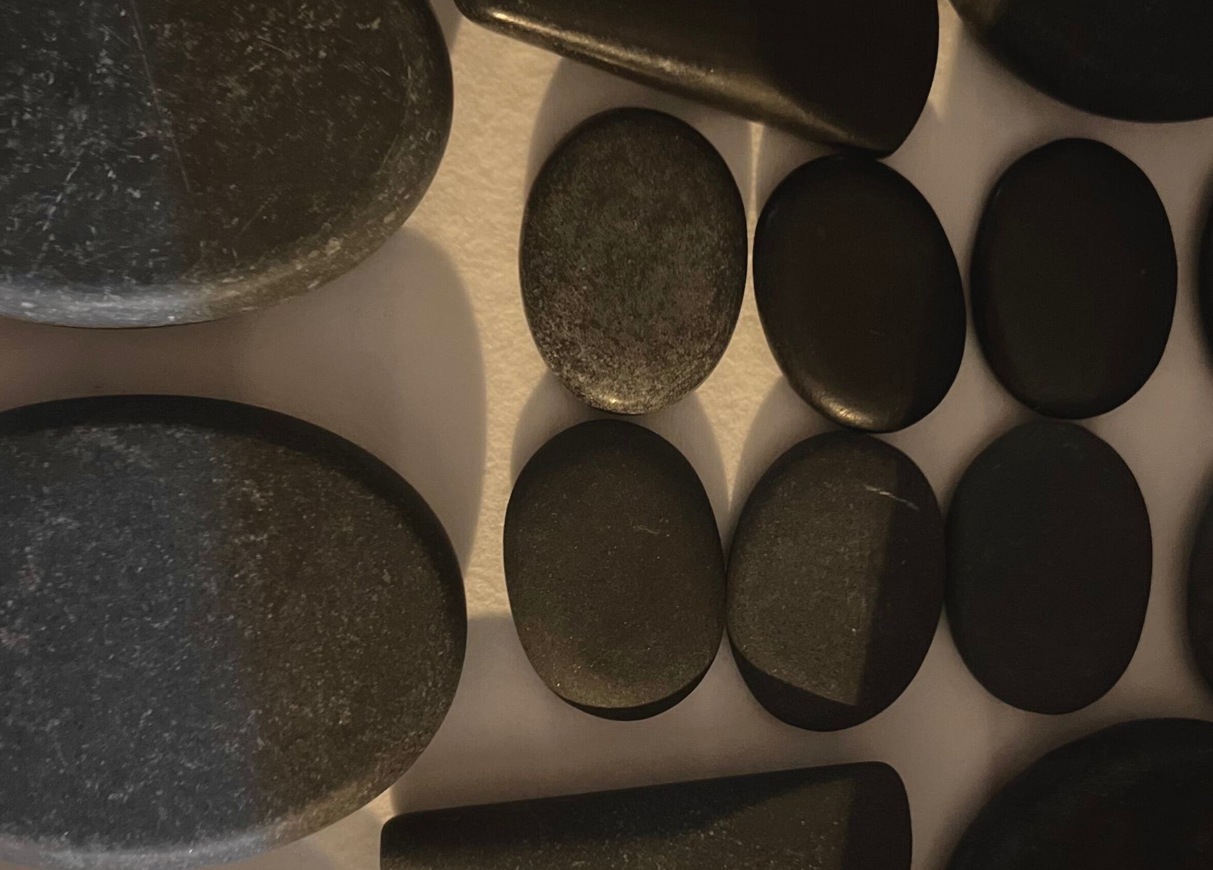 Therapeutic hot stones at Body By Raquel, Tempe, Arizona, US set for a wellness massage experience.