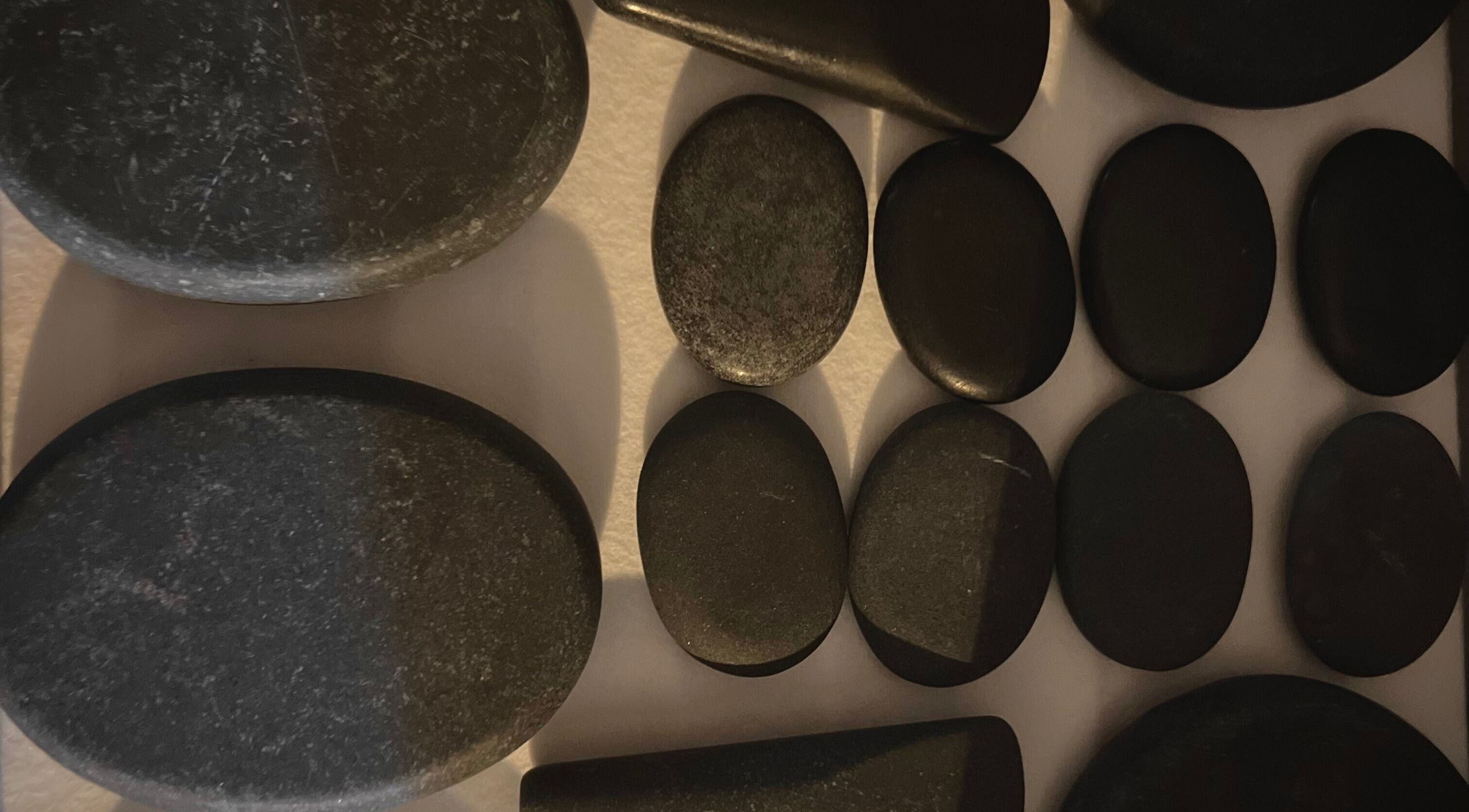 Therapeutic hot stones at Body By Raquel, Tempe, Arizona, US set for a wellness massage experience.