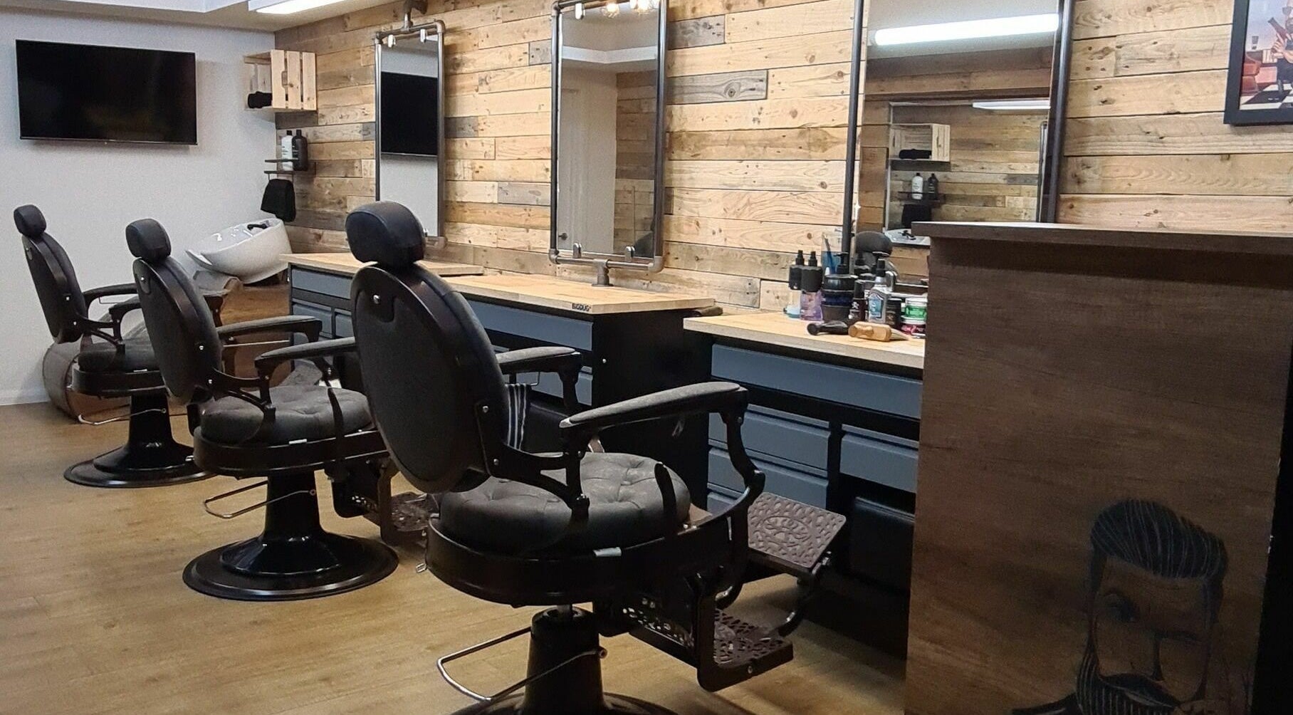 Interior of Harvey's Barbers in Slough, England, GB, featuring vintage barber chairs and wooden decor.