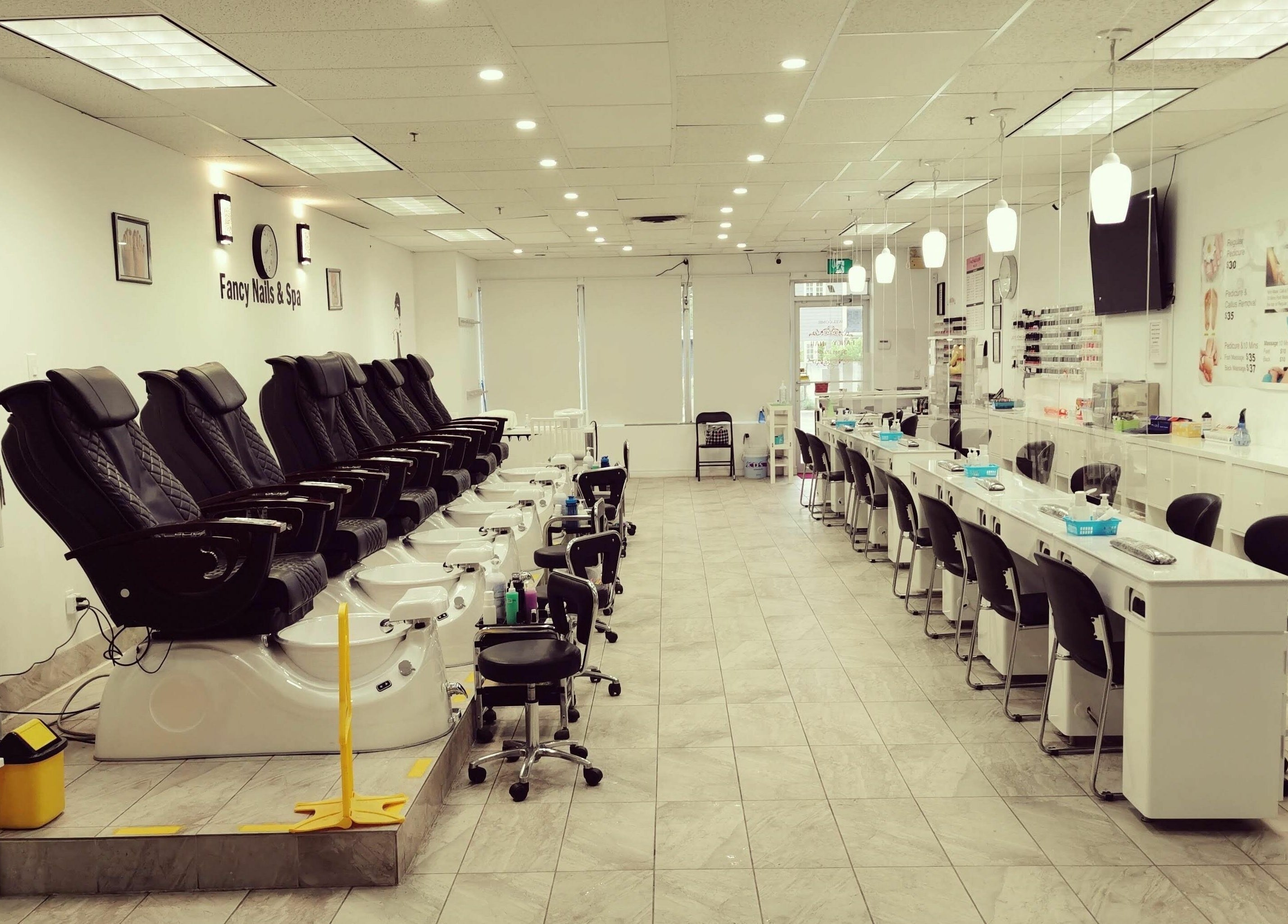 Relaxing interior of Fancy Nails & Spa in Cobourg, Ontario, CA with pedicure chairs and nail stations.