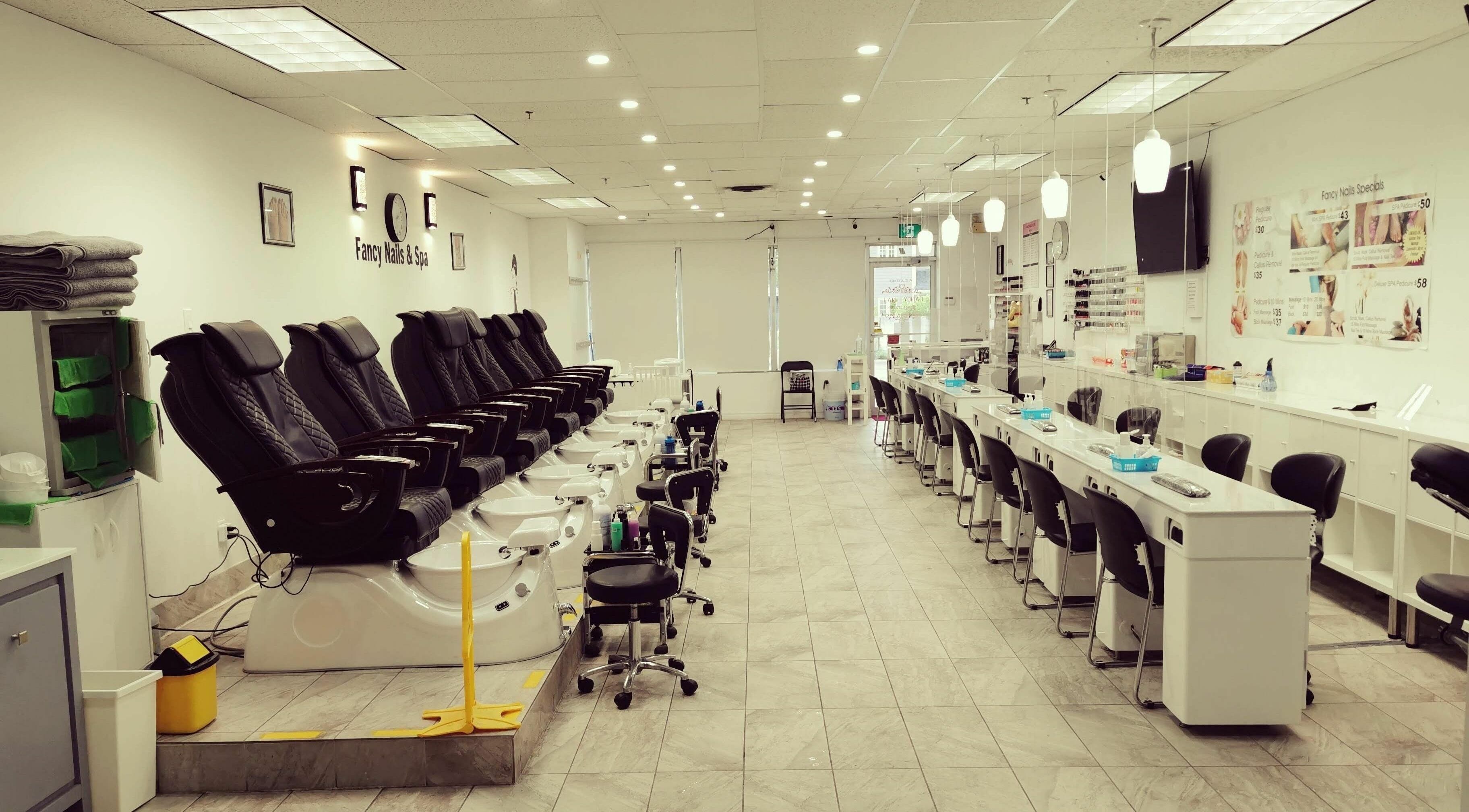 Relaxing interior of Fancy Nails & Spa in Cobourg, Ontario, CA with pedicure chairs and nail stations.