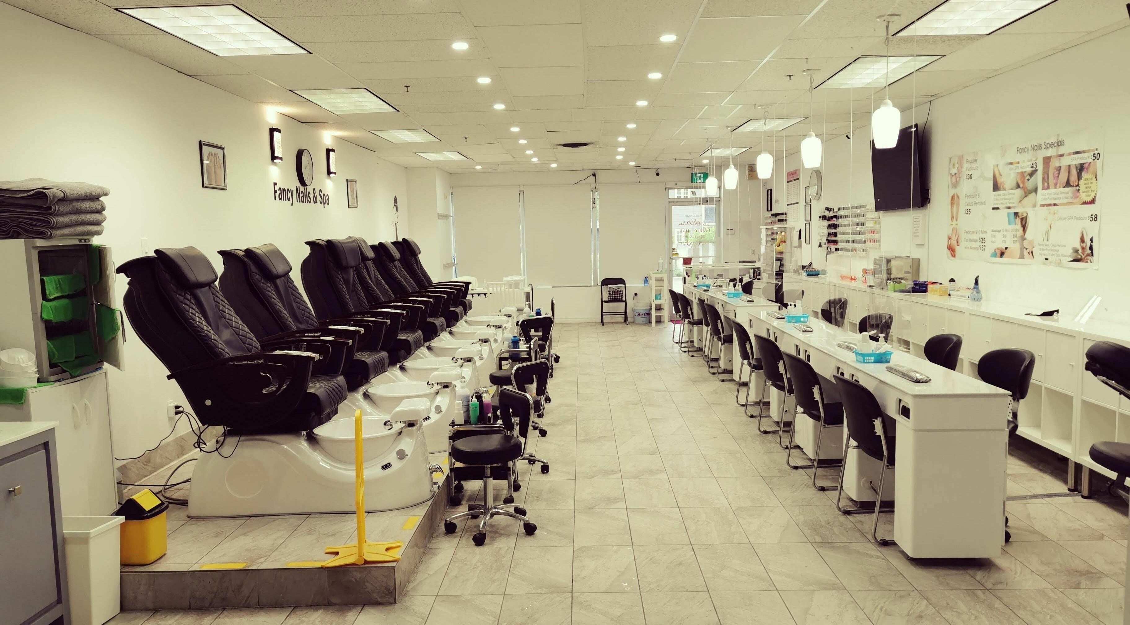 Relaxing interior of Fancy Nails & Spa in Cobourg, Ontario, CA with pedicure chairs and nail stations.