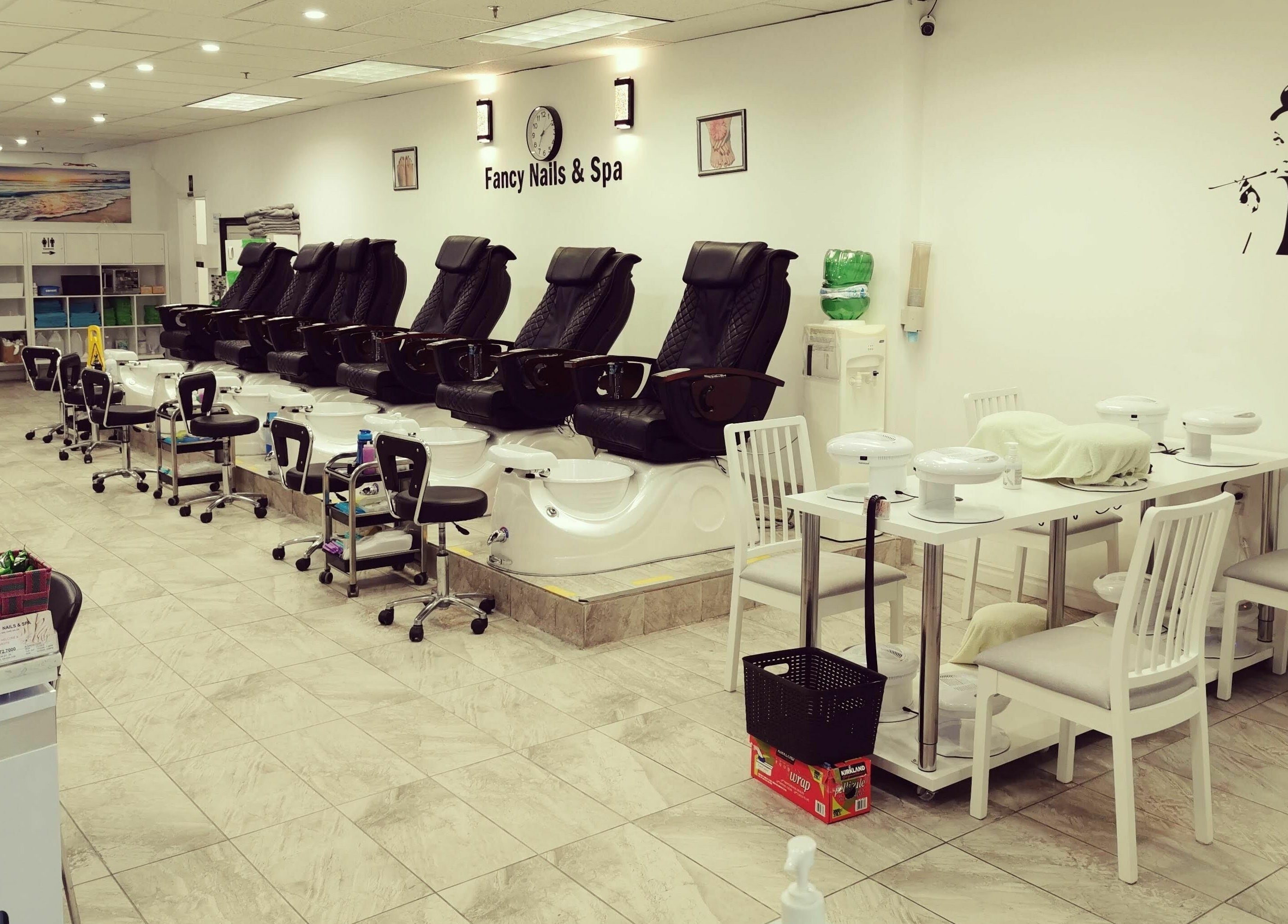 Elegant pedicure area at Fancy Nails & Spa, Cobourg, Ontario, CA, featuring sleek black chairs and modern decor.