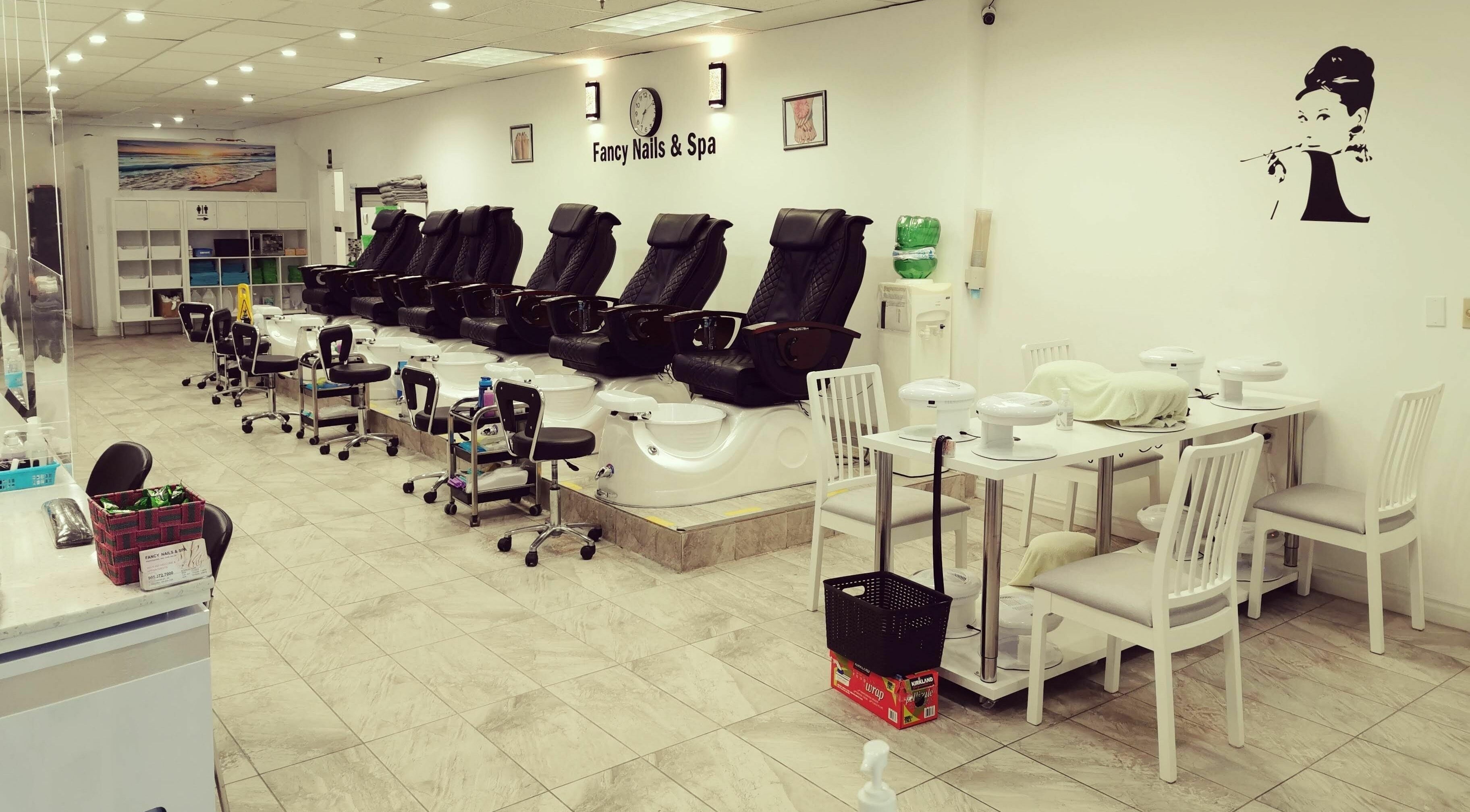 Elegant pedicure area at Fancy Nails & Spa, Cobourg, Ontario, CA, featuring sleek black chairs and modern decor.