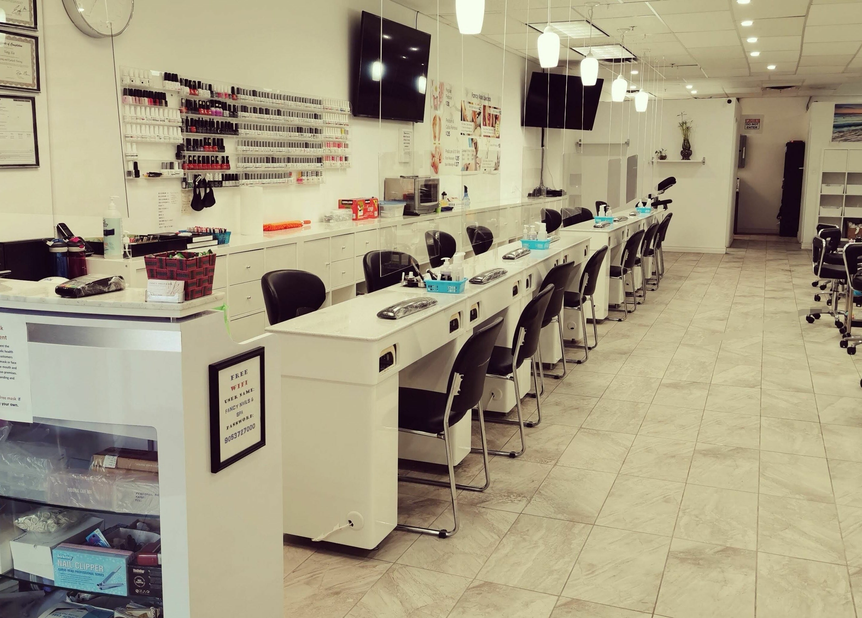 Elegant interior of Fancy Nails & Spa in Cobourg, Ontario, CA showcasing nail service stations and modern decor.