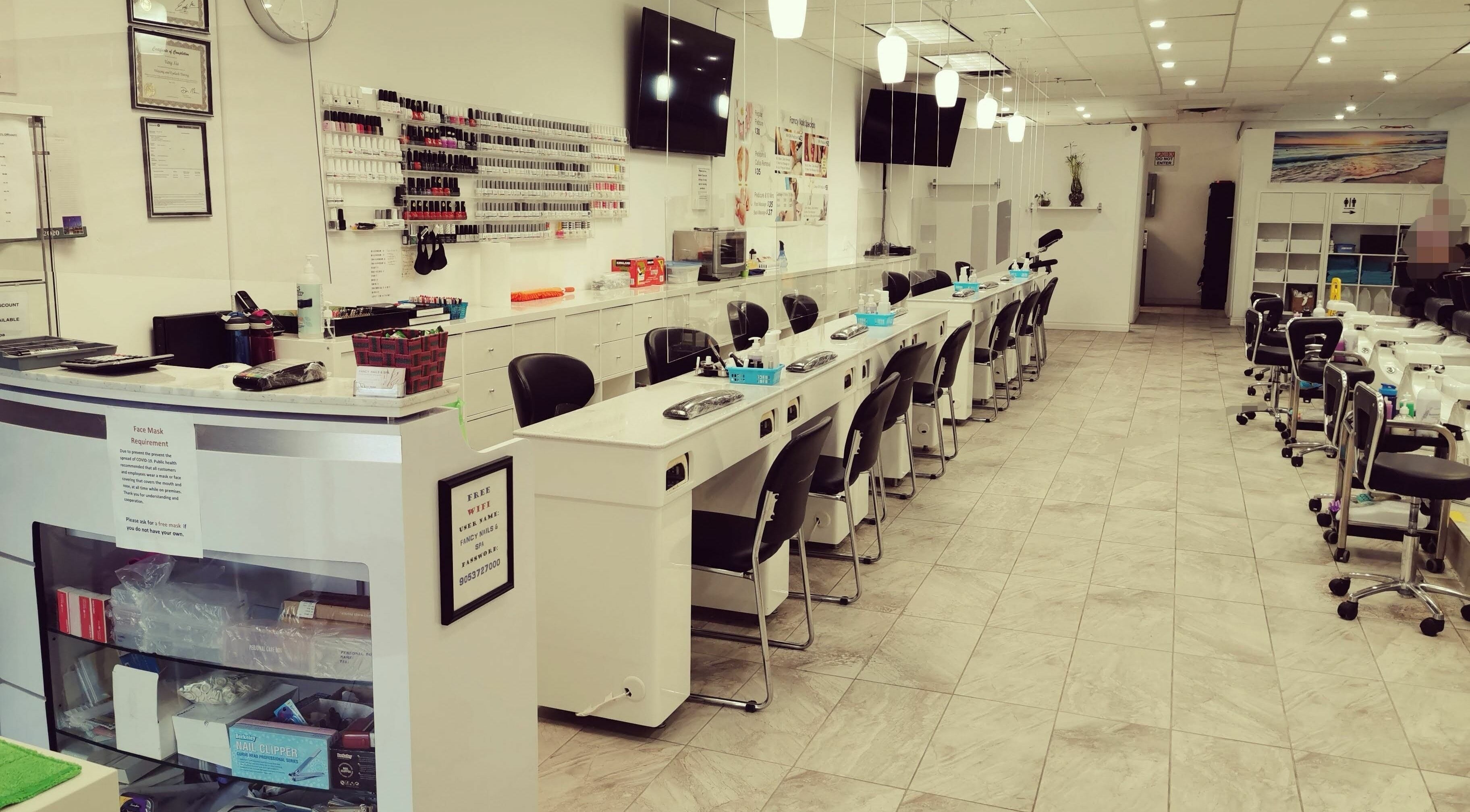 Elegant interior of Fancy Nails & Spa in Cobourg, Ontario, CA showcasing nail service stations and modern decor.