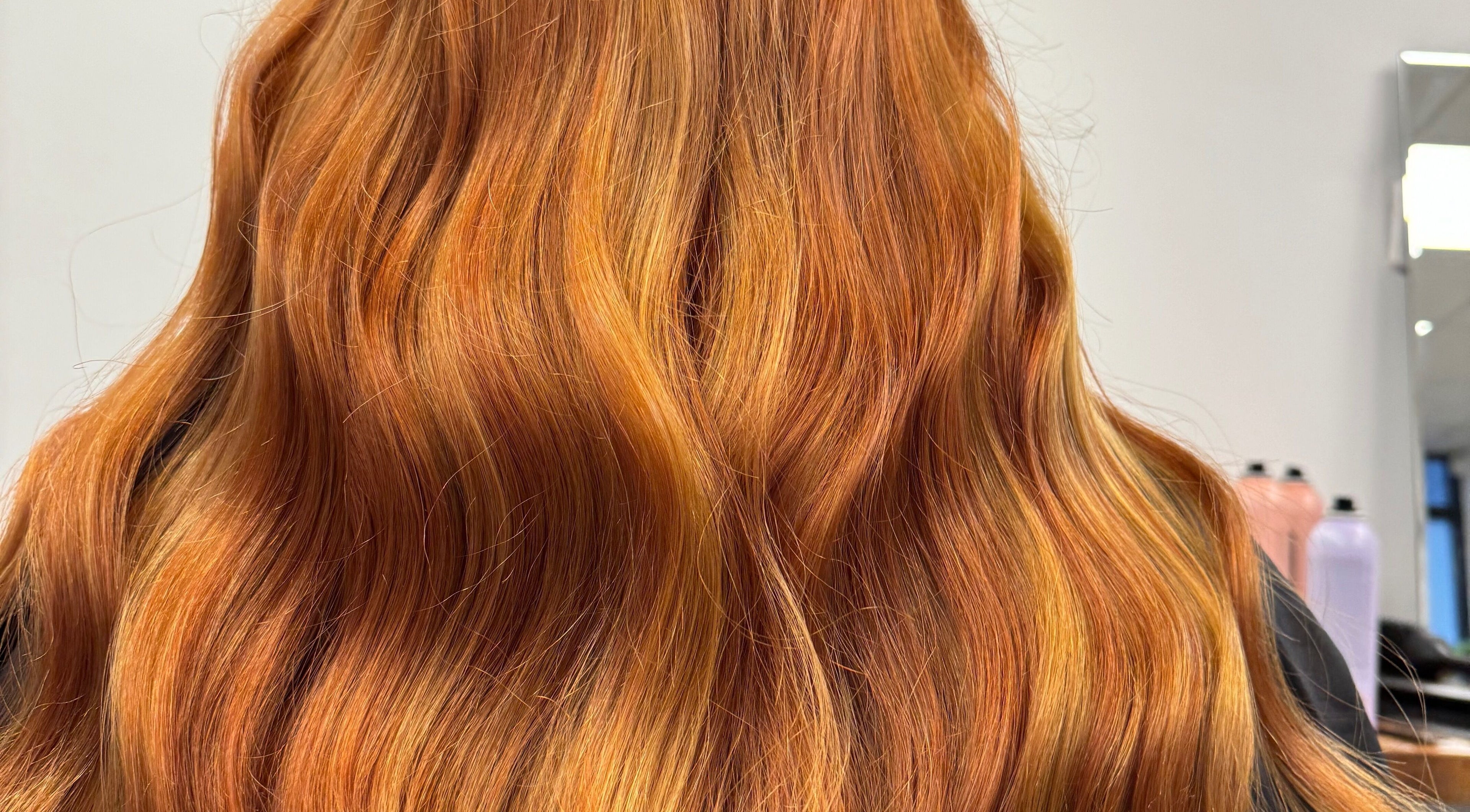 Lustrous copper hair styled at Revive With Ross, Cardiff, Wales, GB. Radiant waves enhance natural beauty.