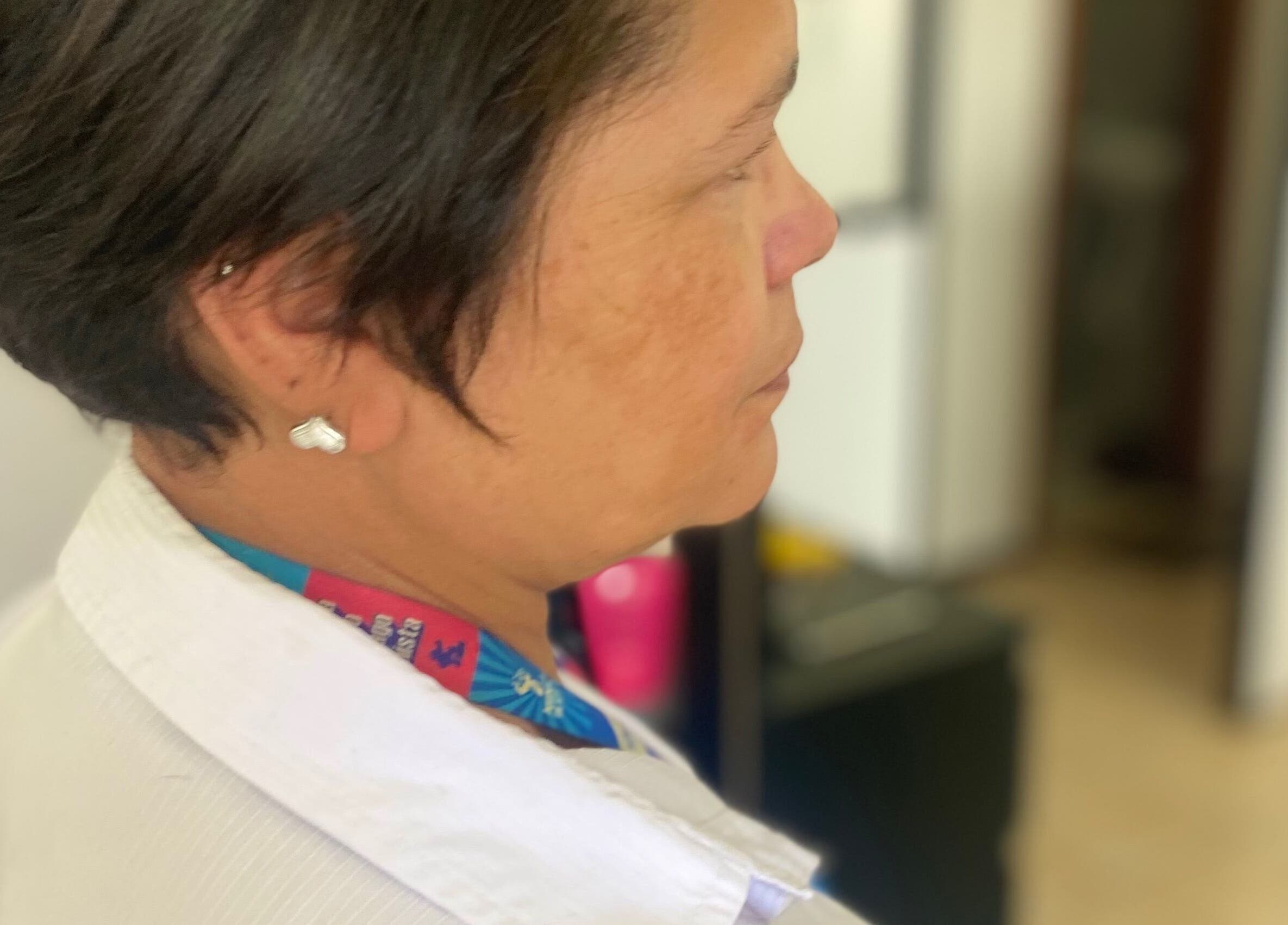 Mulher de perfil usando jaleco em Studio Helcio Costa, Distrito Federal, BR.