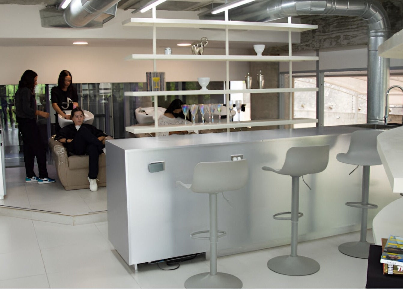 Moderno salón de belleza en Jennifer Araujo Signature, Caracas, Miranda, VE, con cómodos asientos y área de lavado.