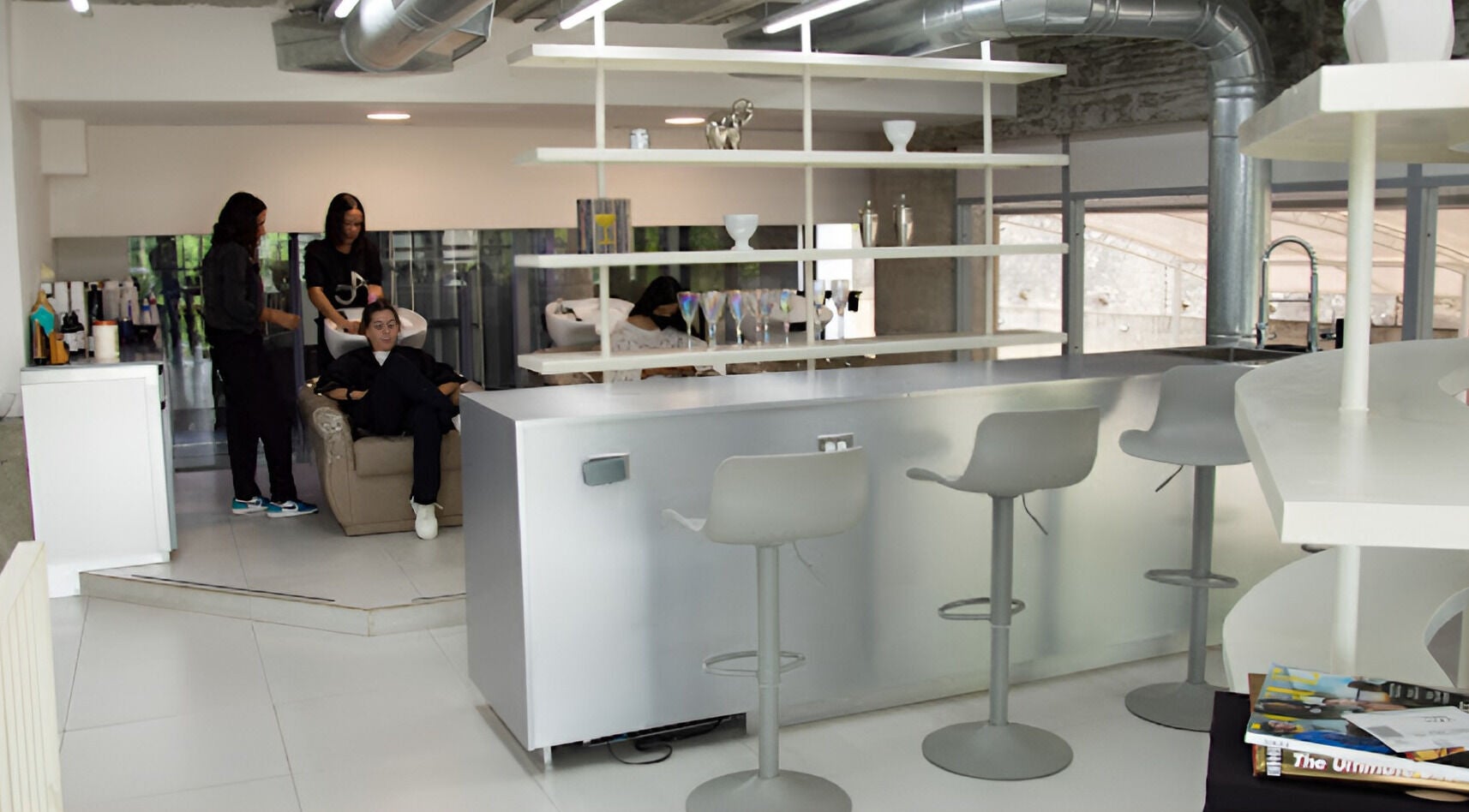 Moderno salón de belleza en Jennifer Araujo Signature, Caracas, Miranda, VE, con cómodos asientos y área de lavado.