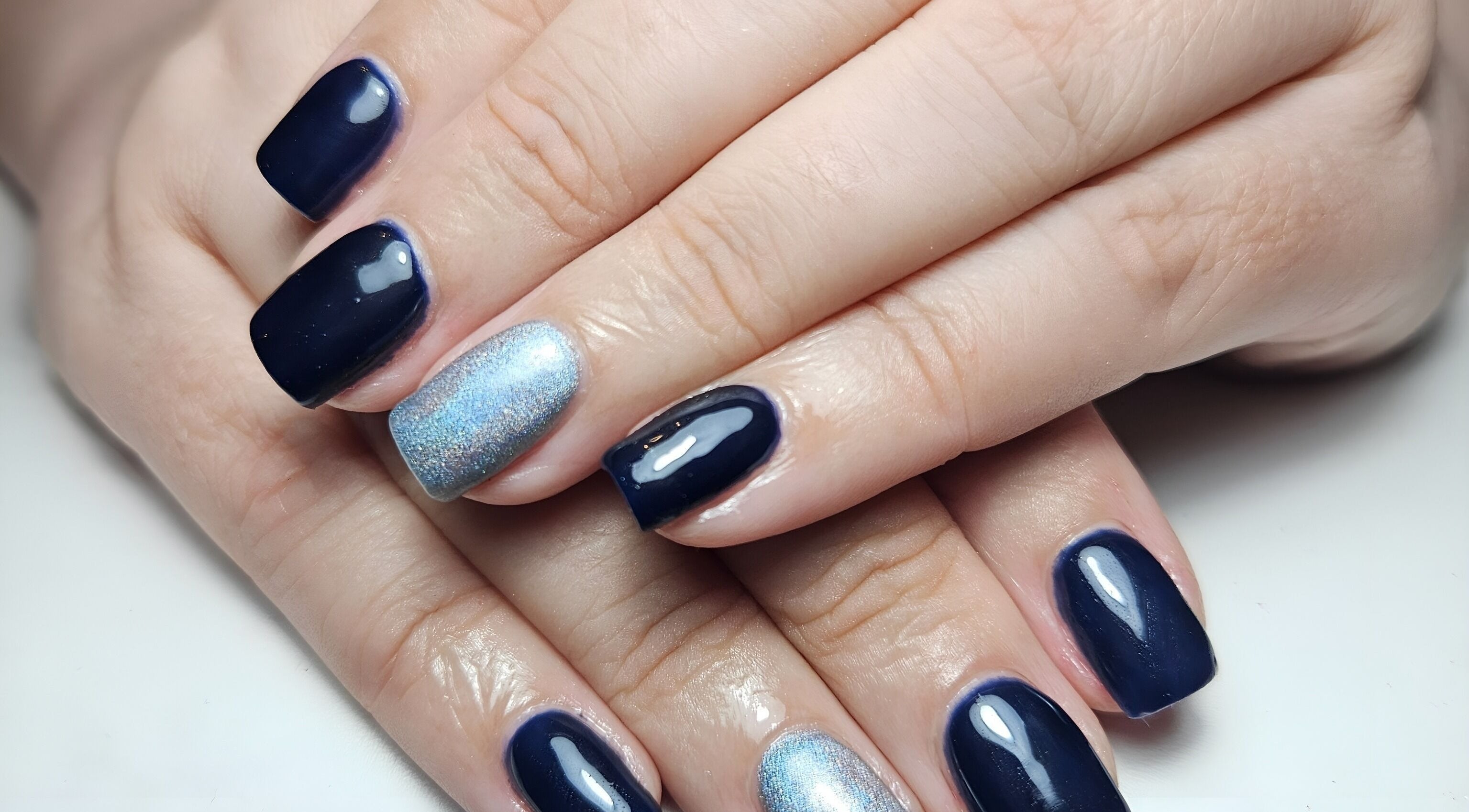Navy and silver nails at Scarra Beauty, Oban, Scotland, GB offer a chic, polished look in a stunning design.