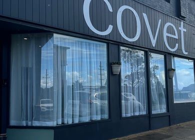 Exterior of Covet Beauty salon in Waratah, New South Wales, AU, showcasing elegant windows and signage.