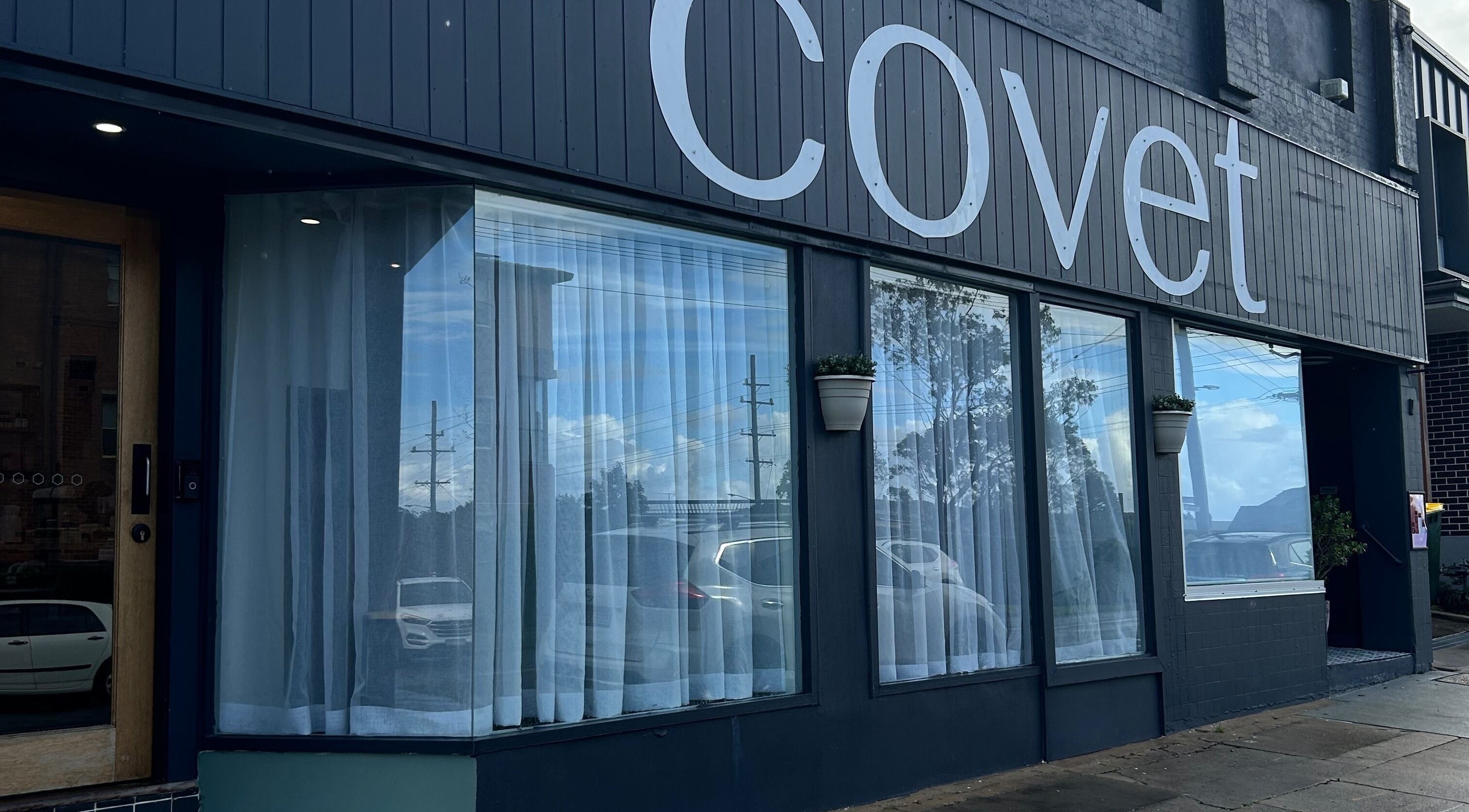 Exterior of Covet Beauty salon in Waratah, New South Wales, AU, showcasing elegant windows and signage.