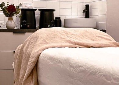 Relaxing treatment room at Covet Beauty, Waratah, New South Wales, AU, featuring cozy bed and elegant decor.