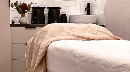 Relaxing treatment room at Covet Beauty, Waratah, New South Wales, AU, featuring cozy bed and elegant decor.