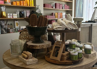 Beauty products displayed at Covet Beauty in Waratah, New South Wales, AU. Natural brushes and creams on wooden table.