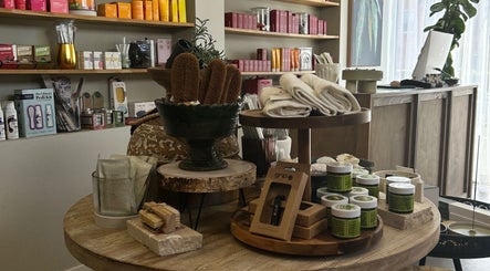 Beauty products displayed at Covet Beauty in Waratah, New South Wales, AU. Natural brushes and creams on wooden table.