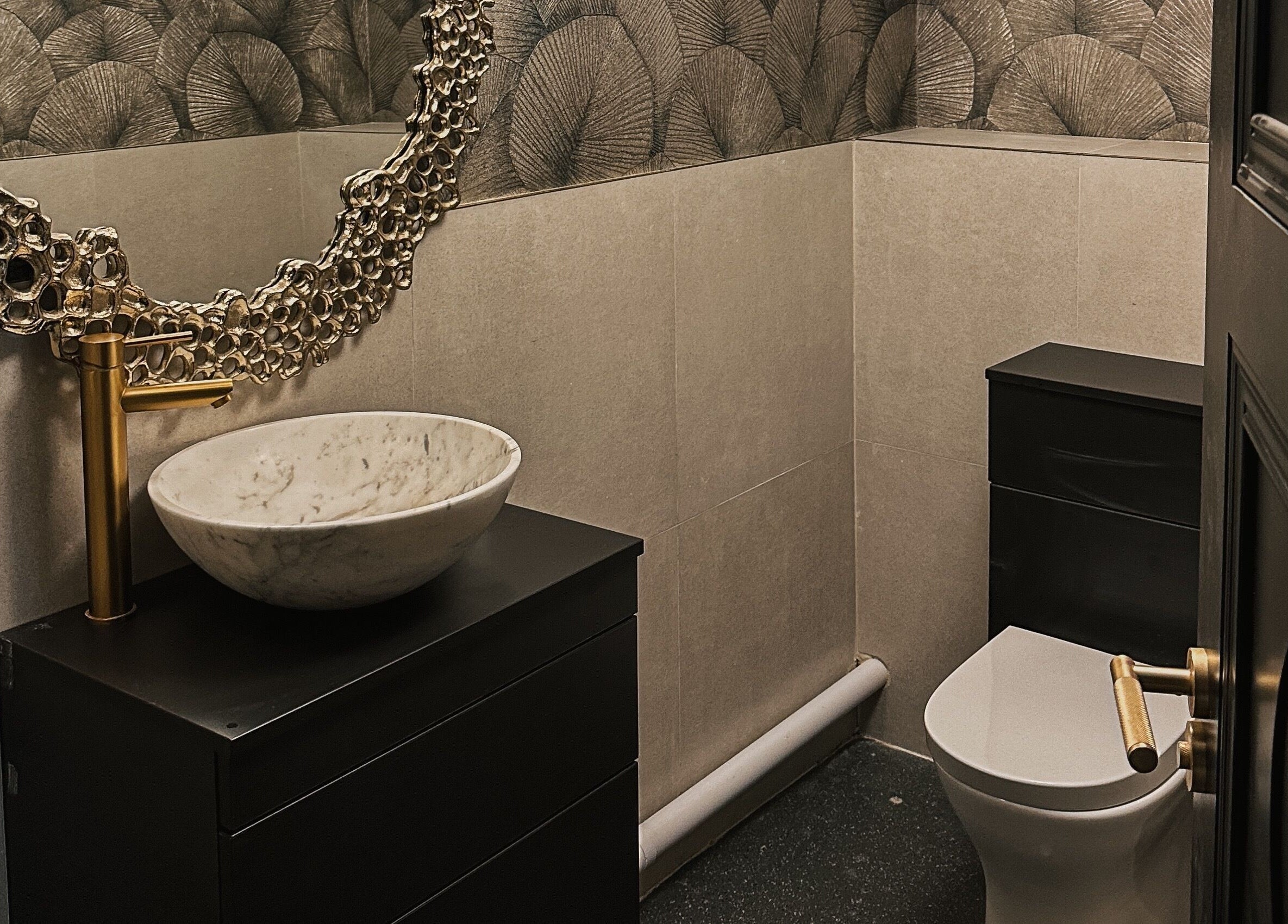 Stylish restroom at Blossom, Neath, Wales, GB featuring ornate mirror and marble sink.