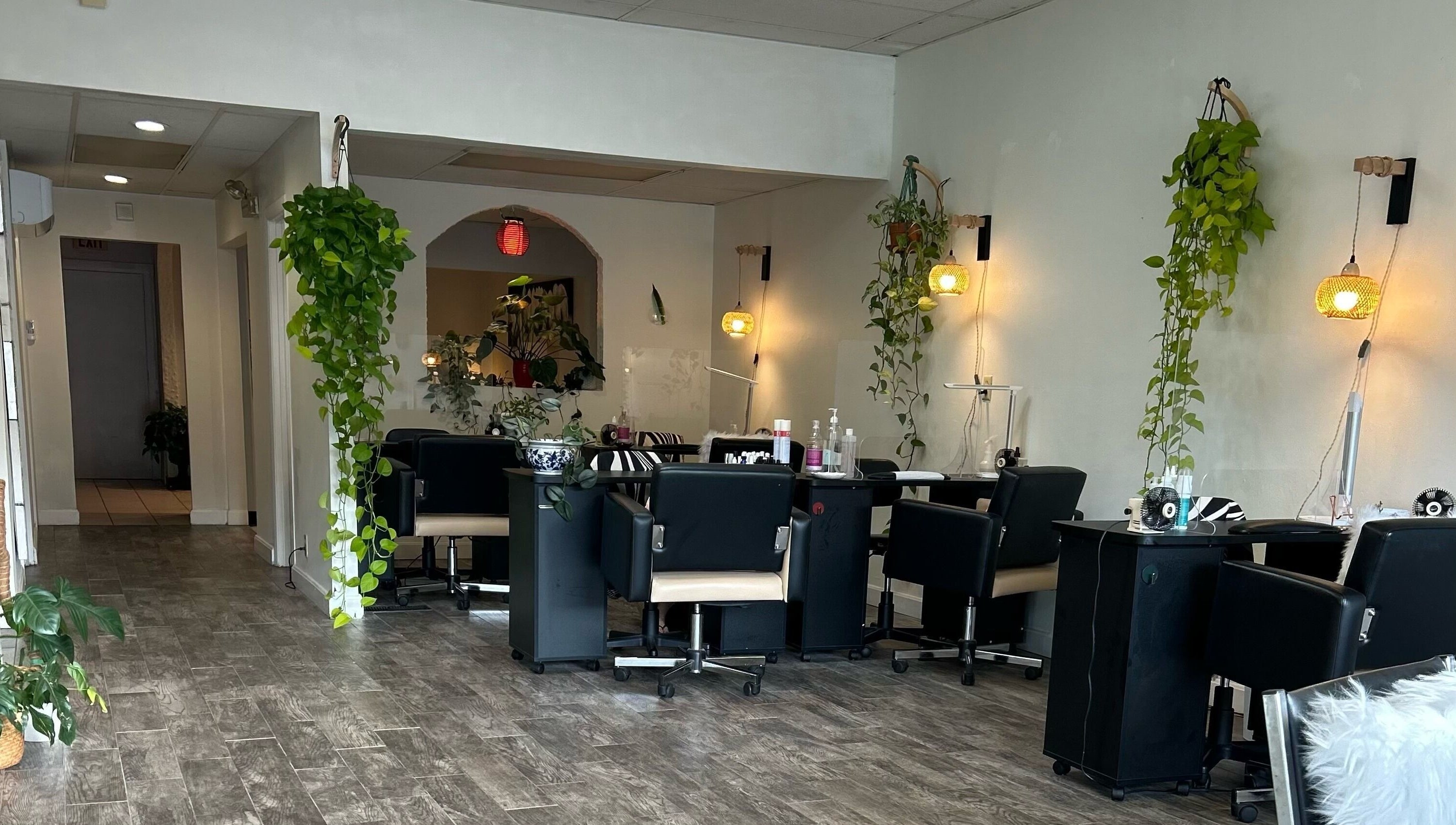 Cozy interior of Nails Essential Spa in Cohasset, Massachusetts, US, featuring stylish nail stations and green decor.