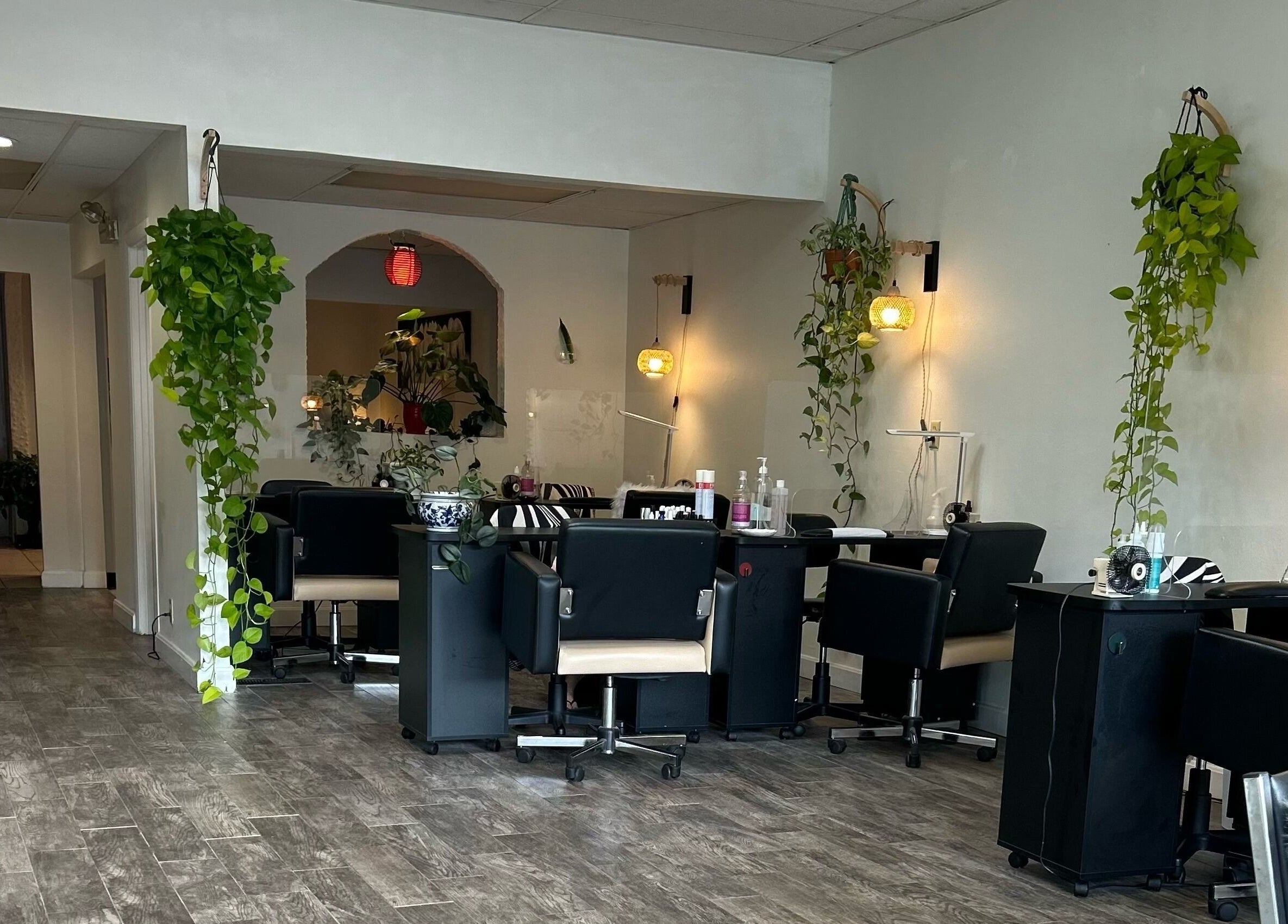 Cozy interior of Nails Essential Spa in Cohasset, Massachusetts, US, featuring stylish nail stations and green decor.