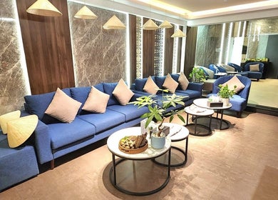 Elegant lounge area at Nón Spa, Đà Nẵng, Đà Nẵng, VN, featuring blue sofas and modern decor.